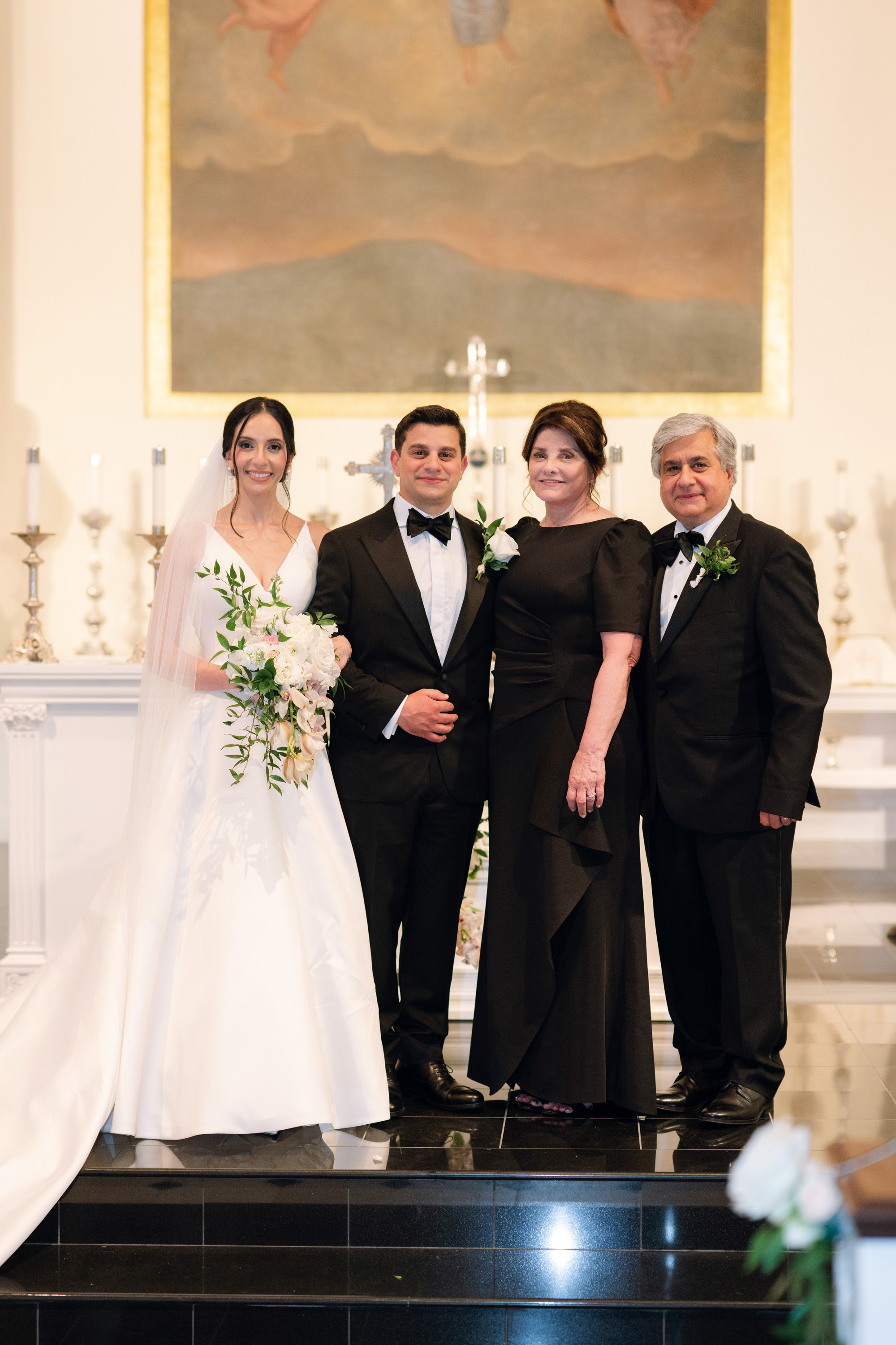 a bride and groom stand in front of a priest