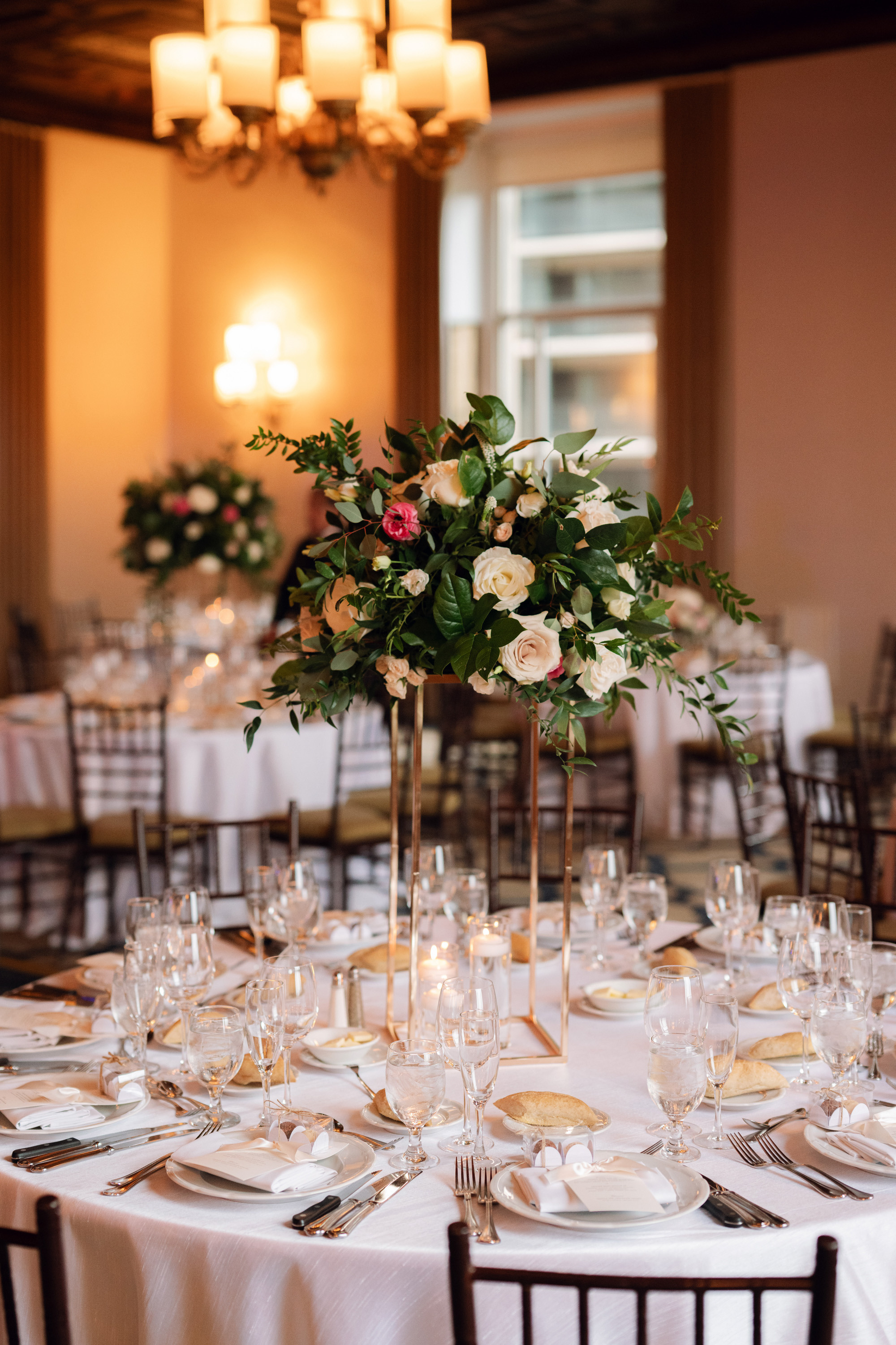 a table with a vase of flowers and candles