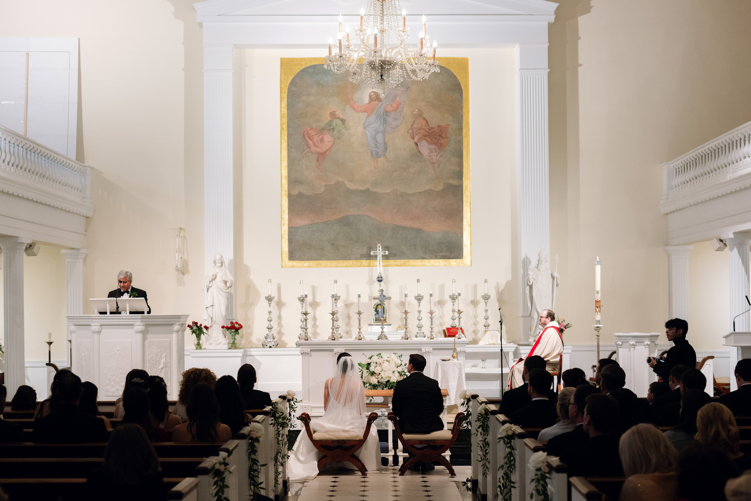 a couple is sitting in a church with a priest