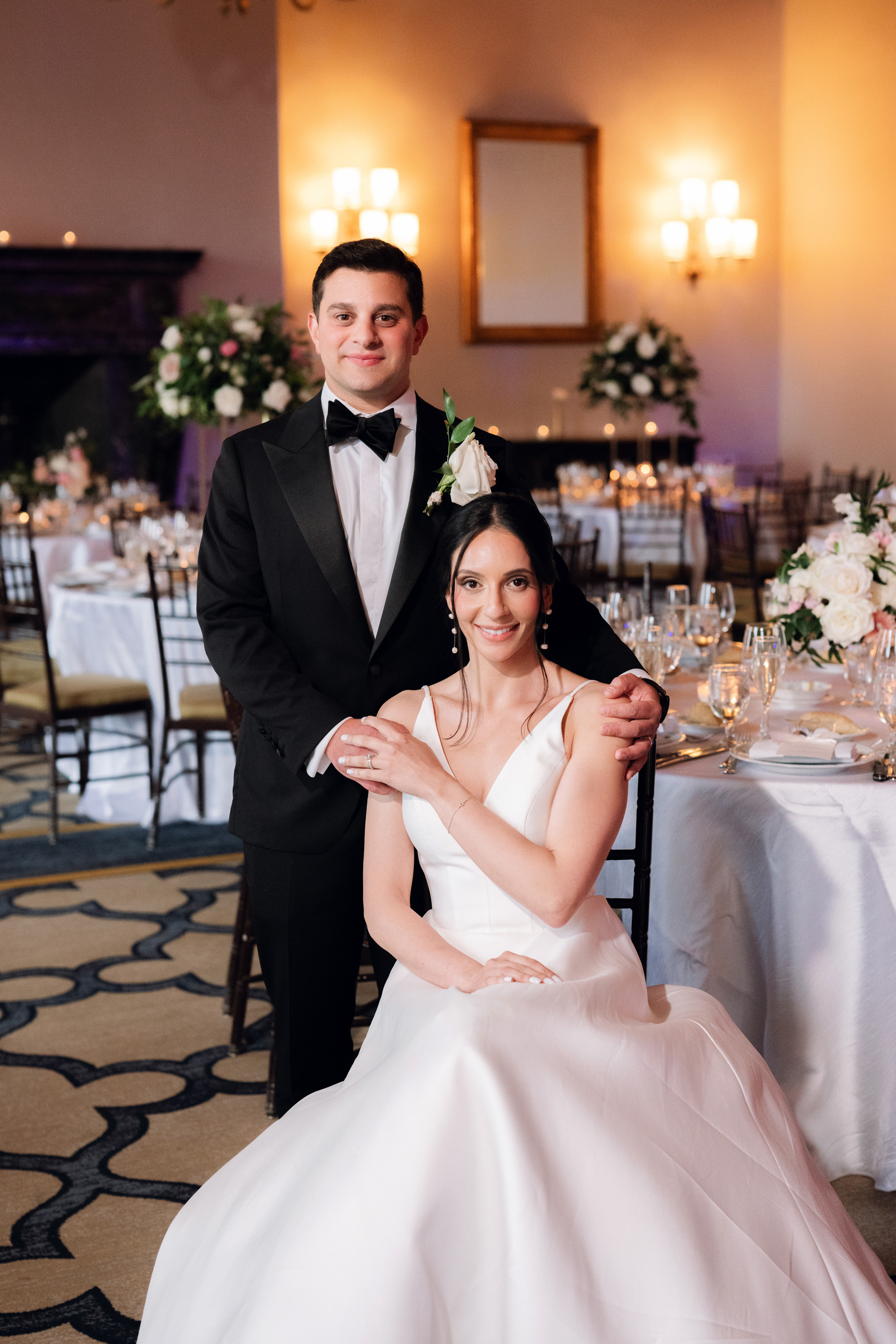 a bride and groom pose for a photo at their wedding reception