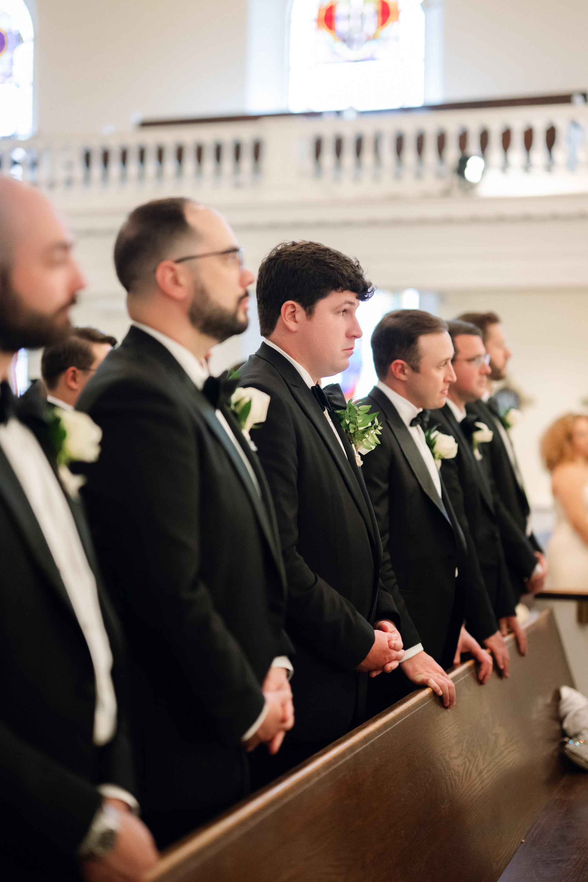 a group of men in suits and ties standing in a church