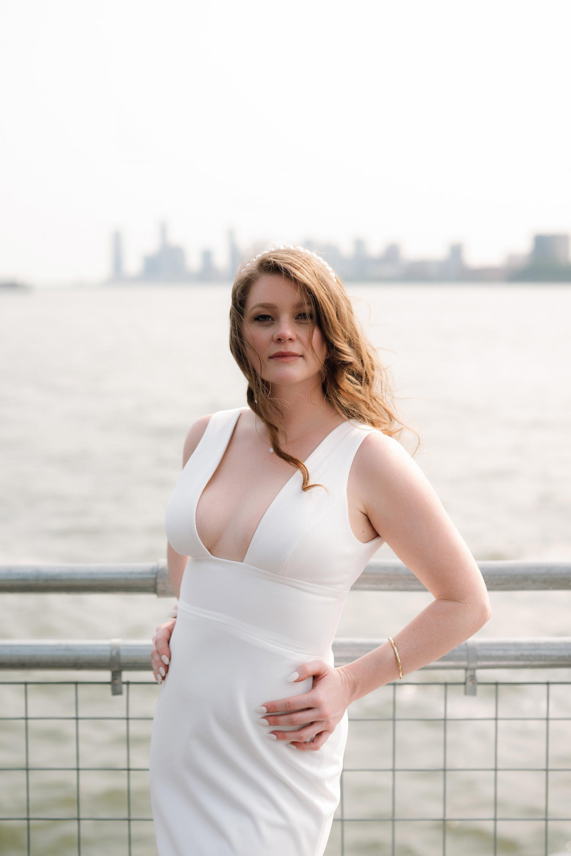 a woman in a white dress standing on a bridge