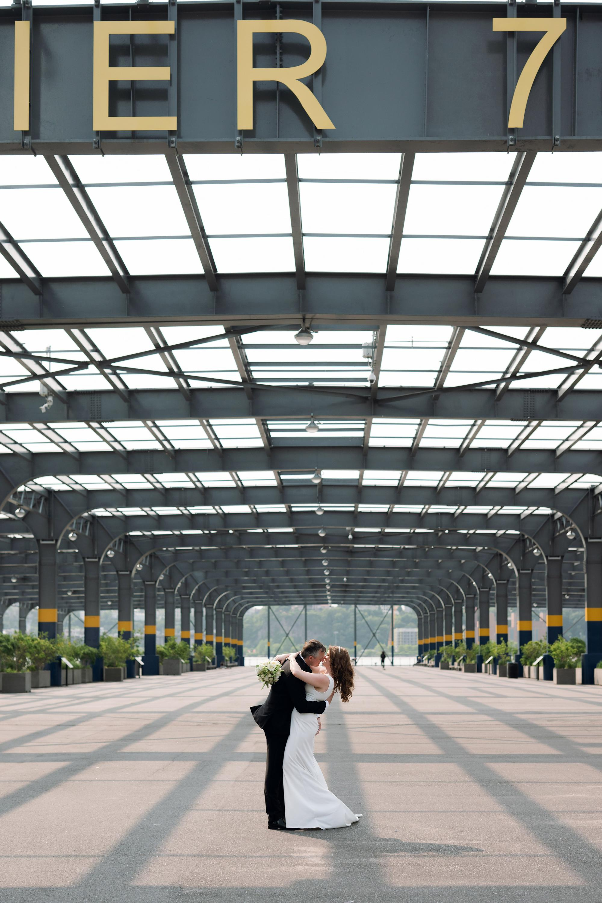 a bride and groom kissing in front of the sign for the city center