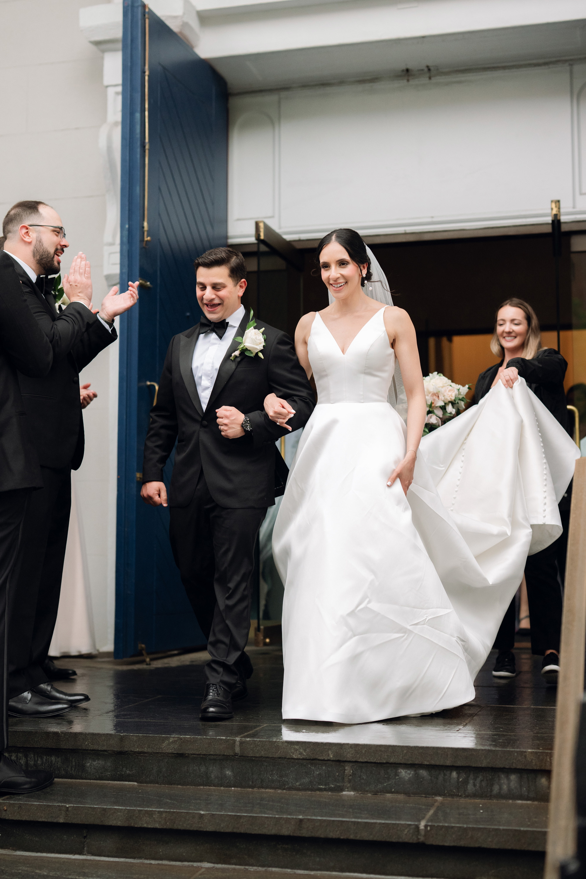 a bride and groom walking down the stairs