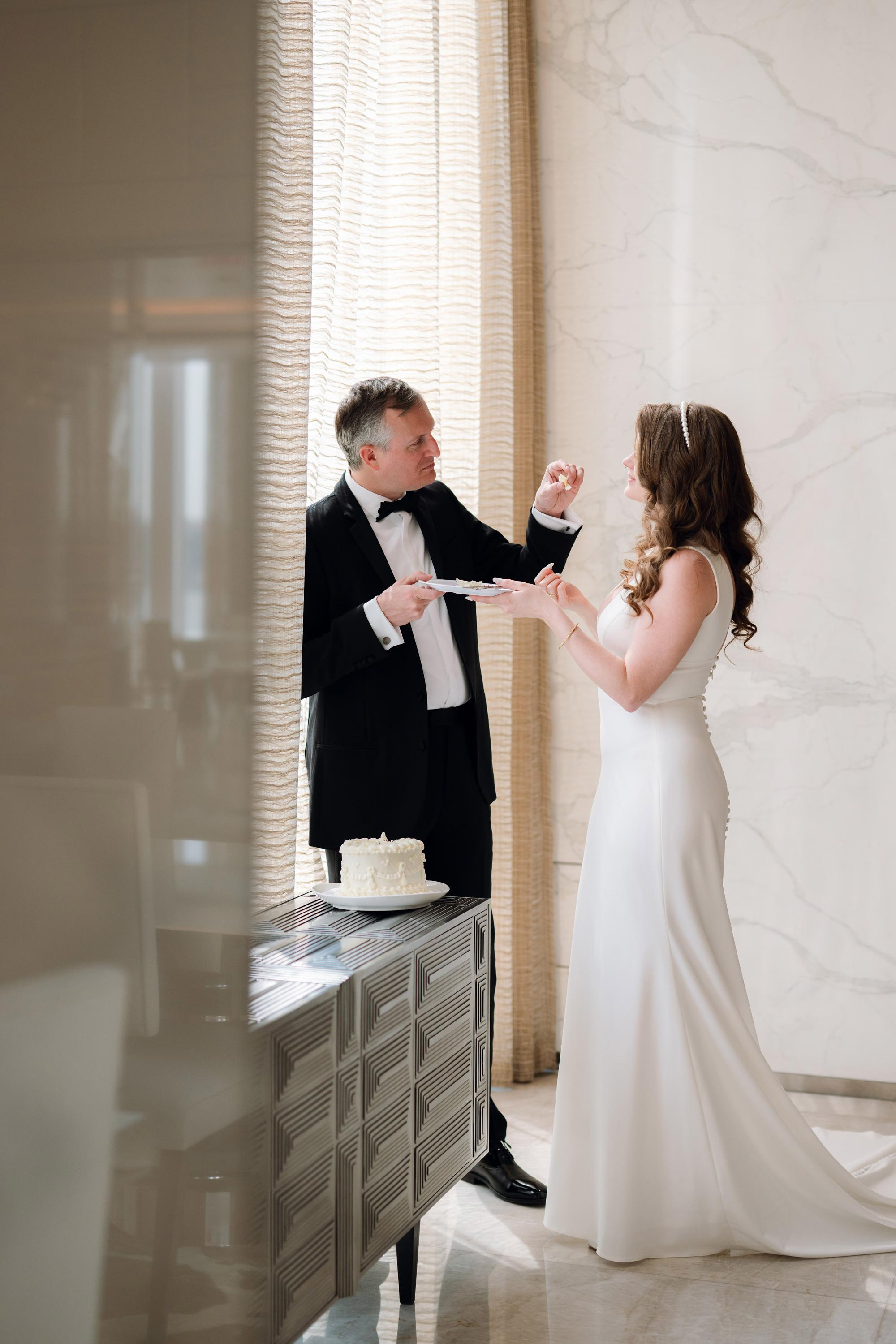 a bride and groom are standing in front of a window