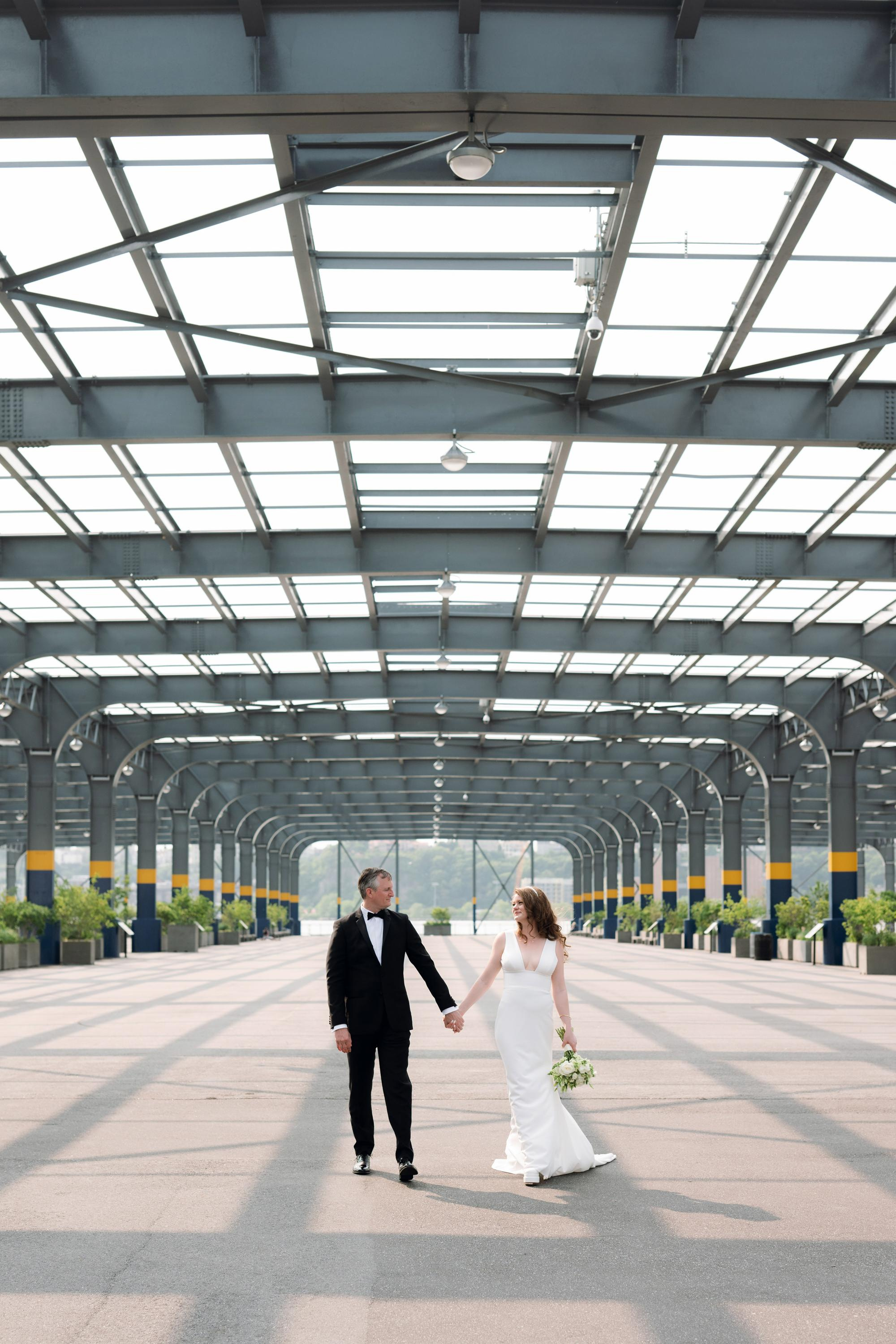 a bride and groom walking through an empty parking