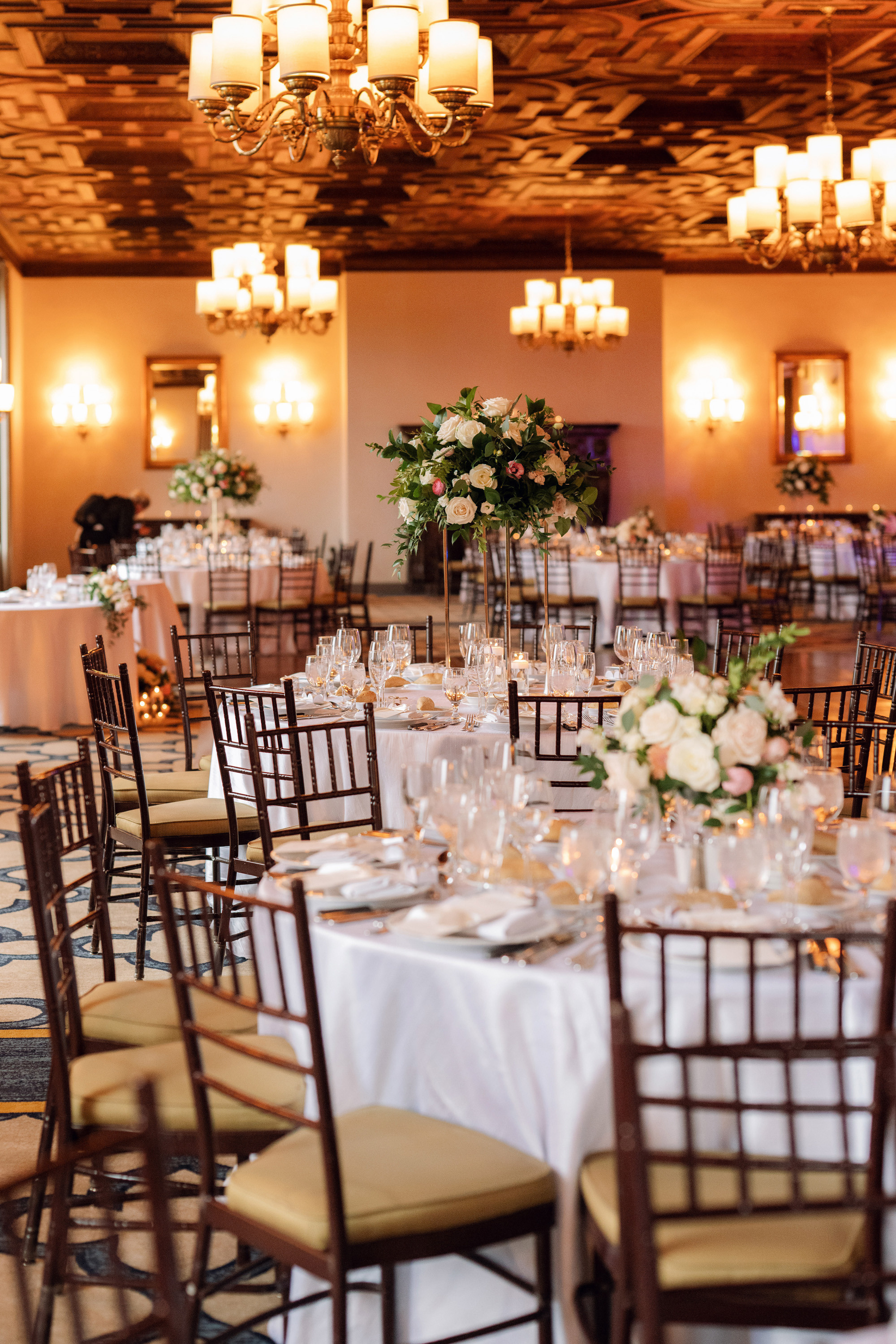 a room with tables and chairs and a chandel