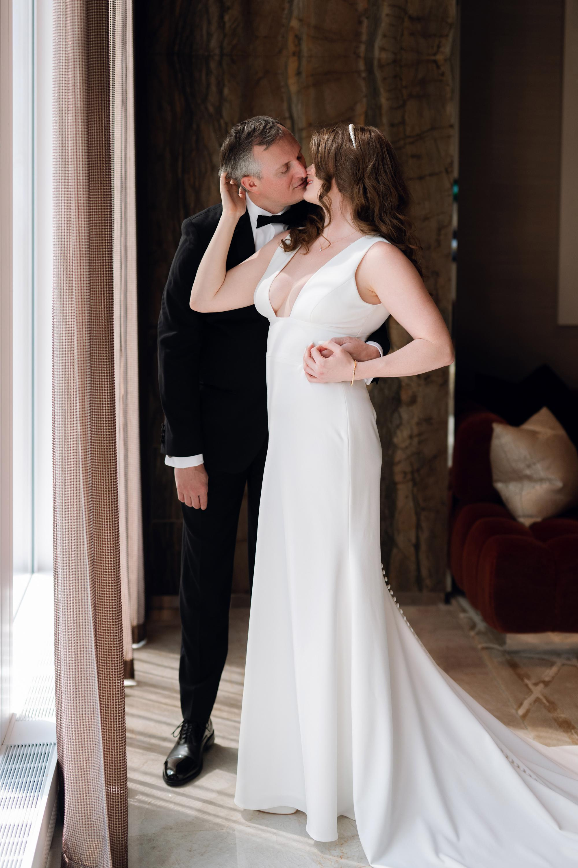 a man and woman in formal attire kissing