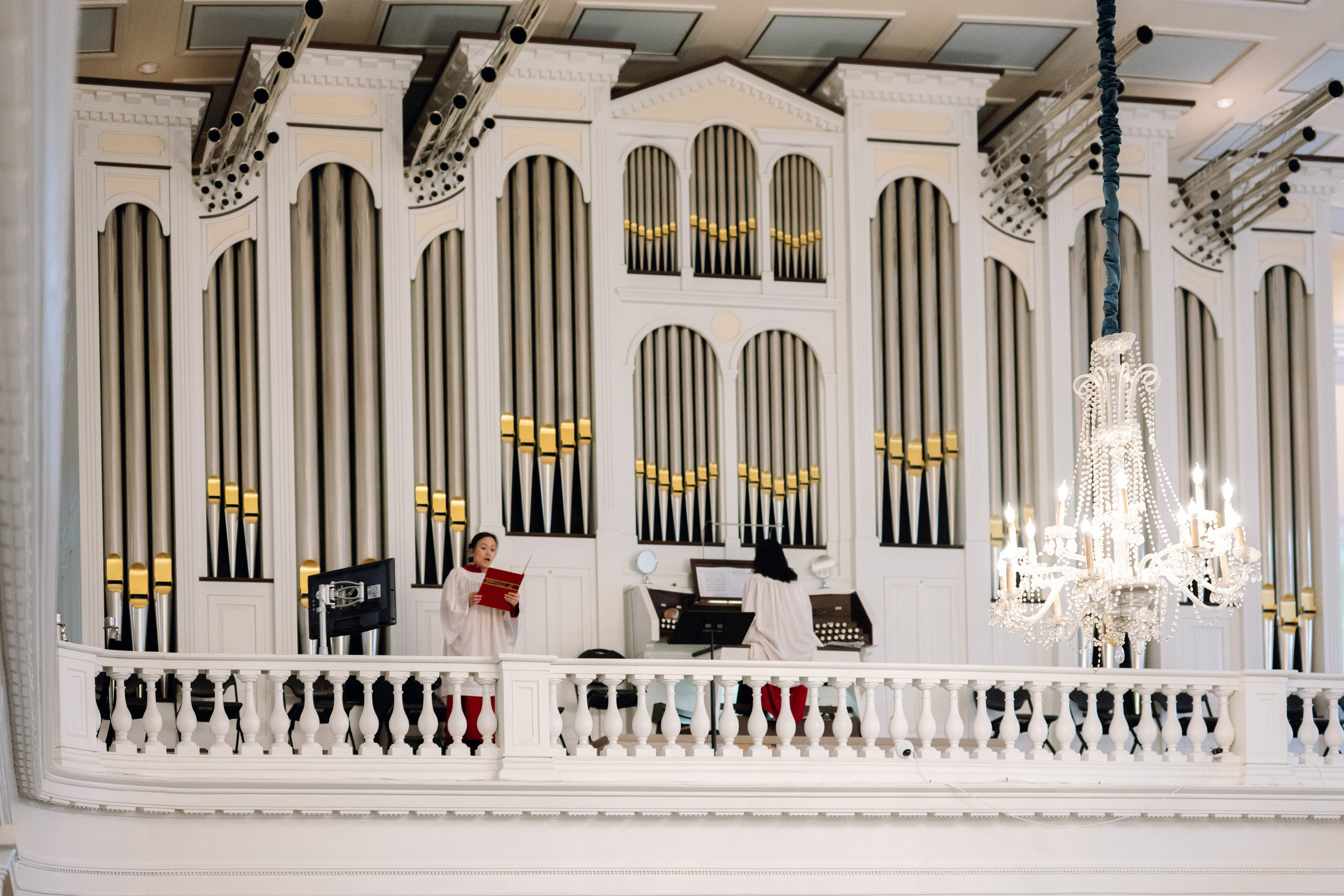 a man sitting on a bench in front of a pipe organ