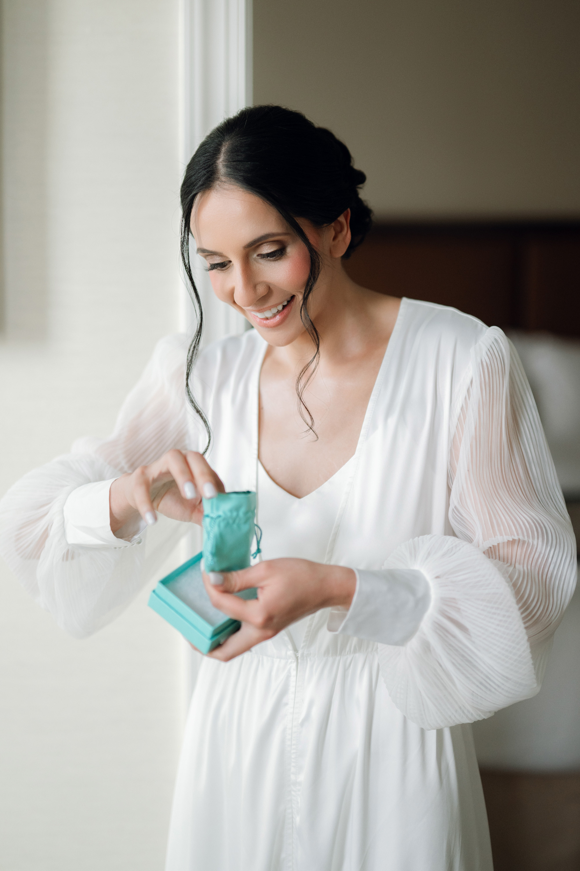 a woman in a white dress holding a green box