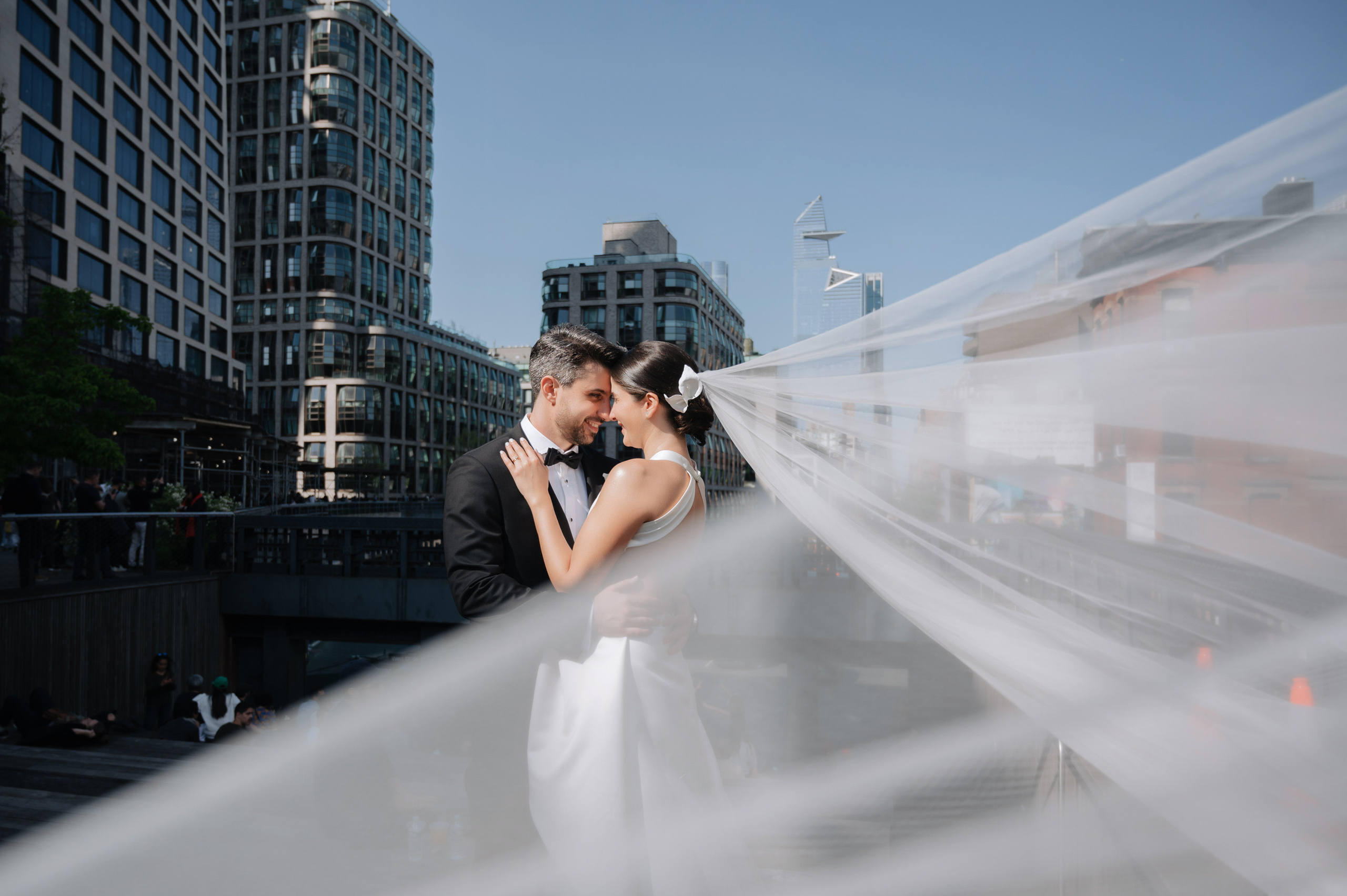 a bride and groom kissing on a bridge