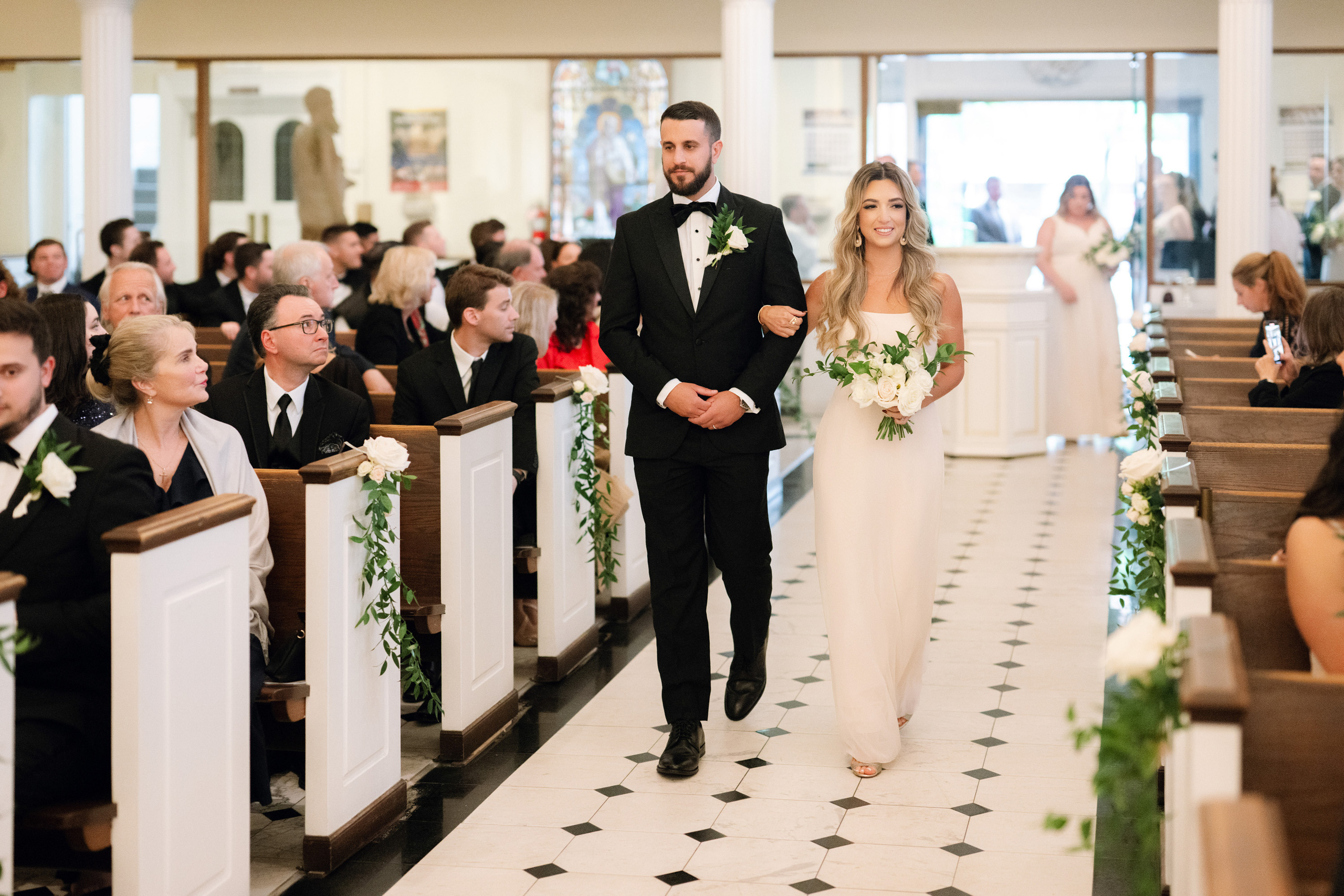 a bride and groom walking down the aisle