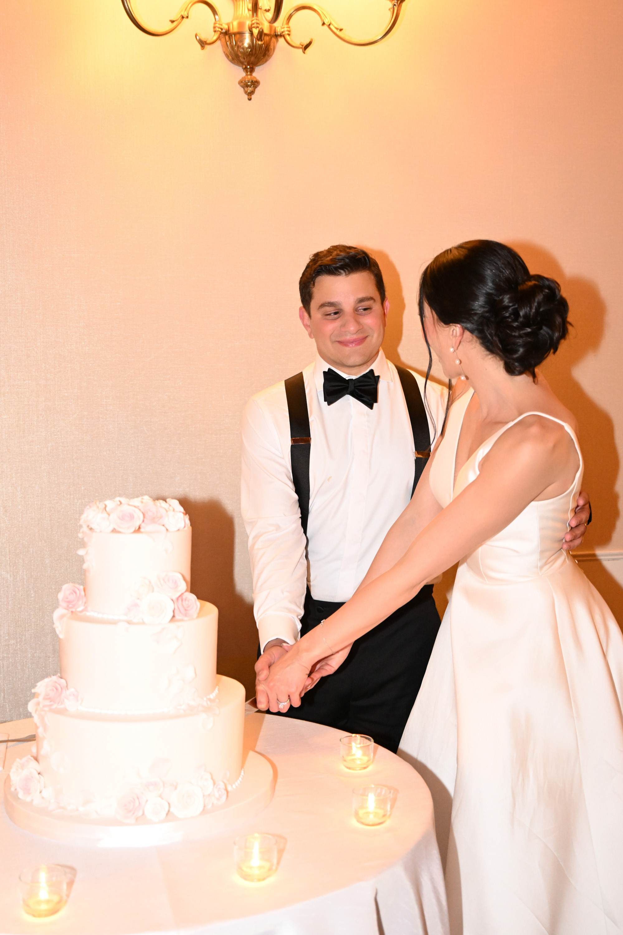 a man and woman cutting a cake together