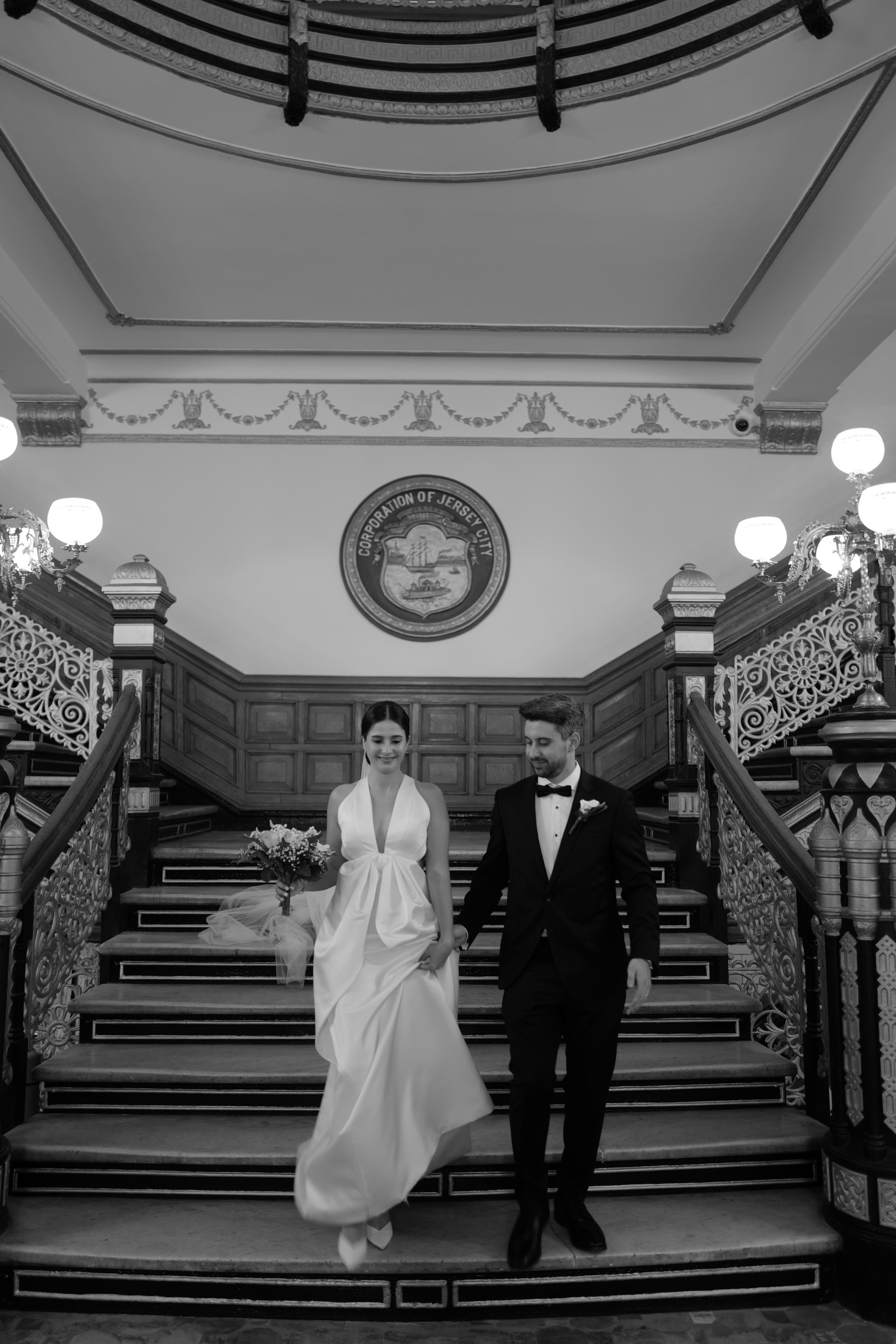a bride and groom walking down the stairs