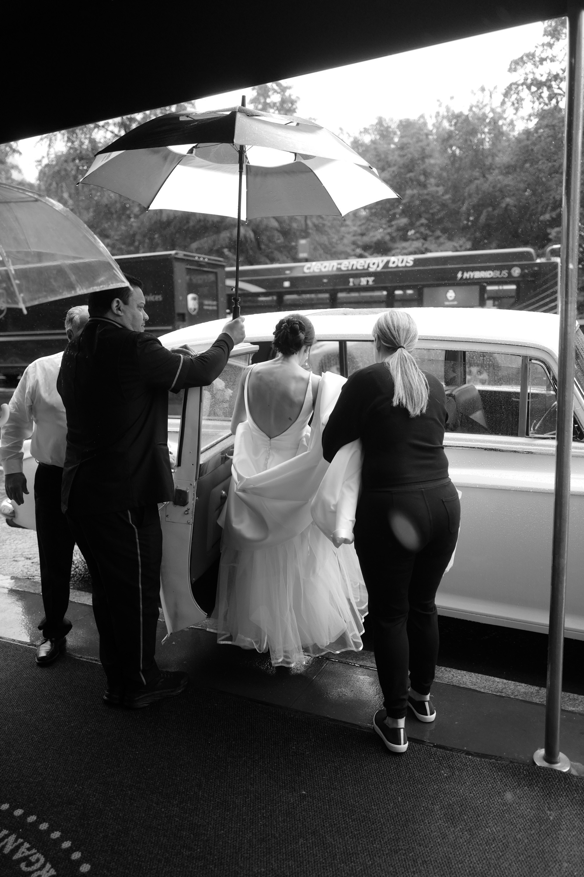 a bride getting into a car with her groom
