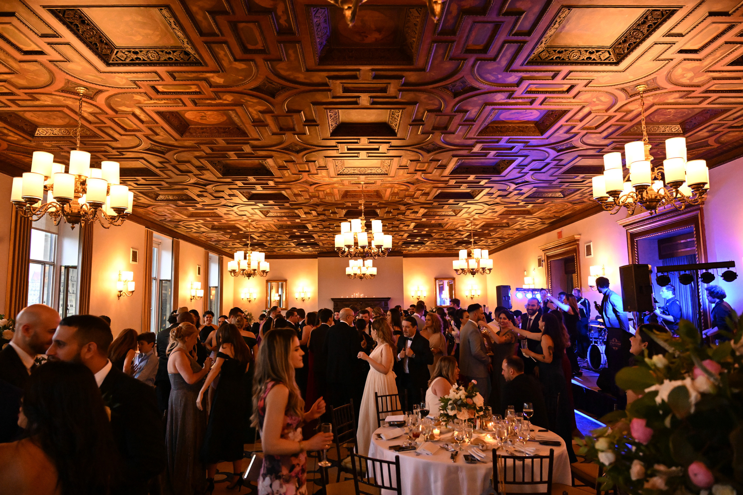 a large room with a ceiling of wood and a couple of people