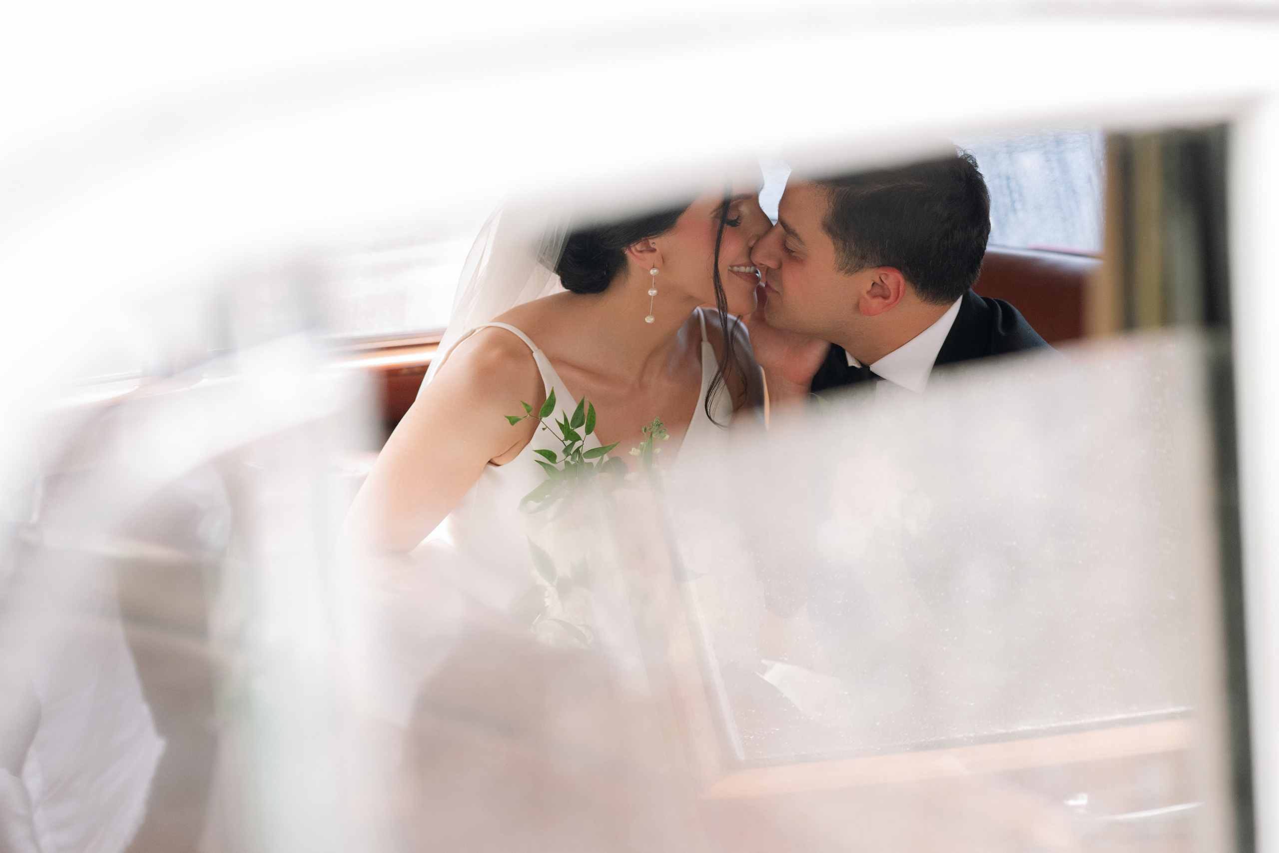 a bride and groom kissing in a car
