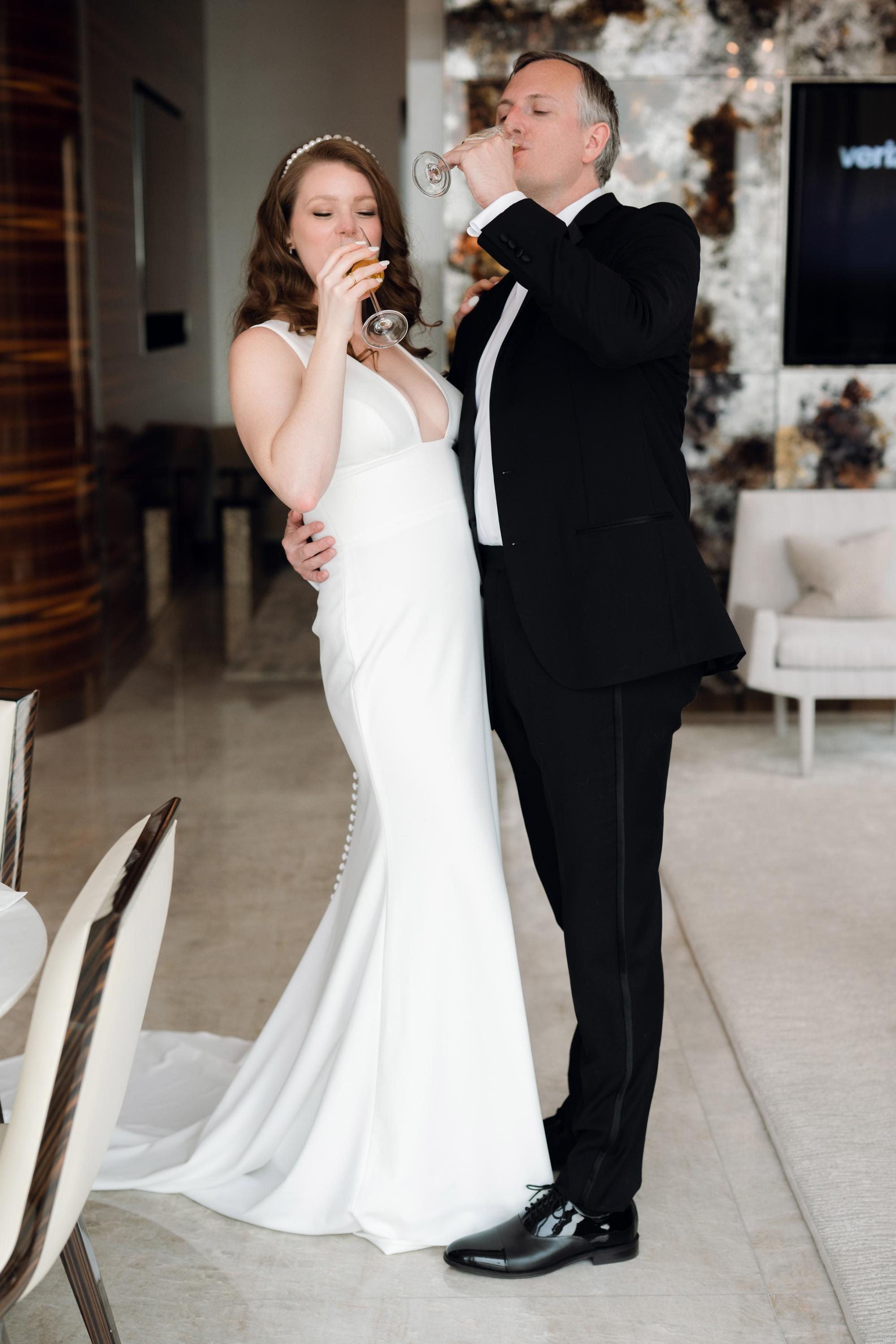 a bride and groom are drinking champagne at their wedding