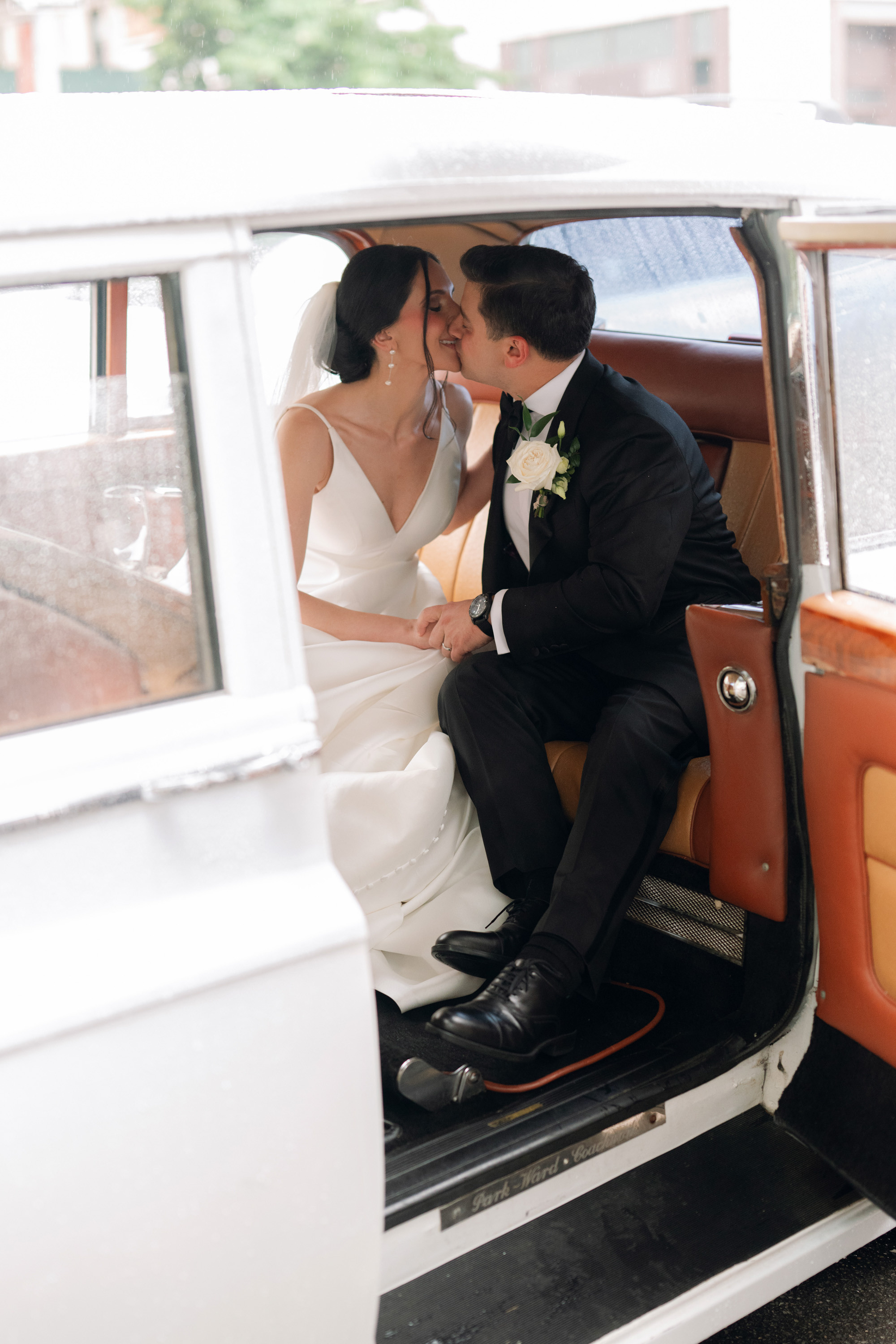 a bride and groom sitting in a vintage car