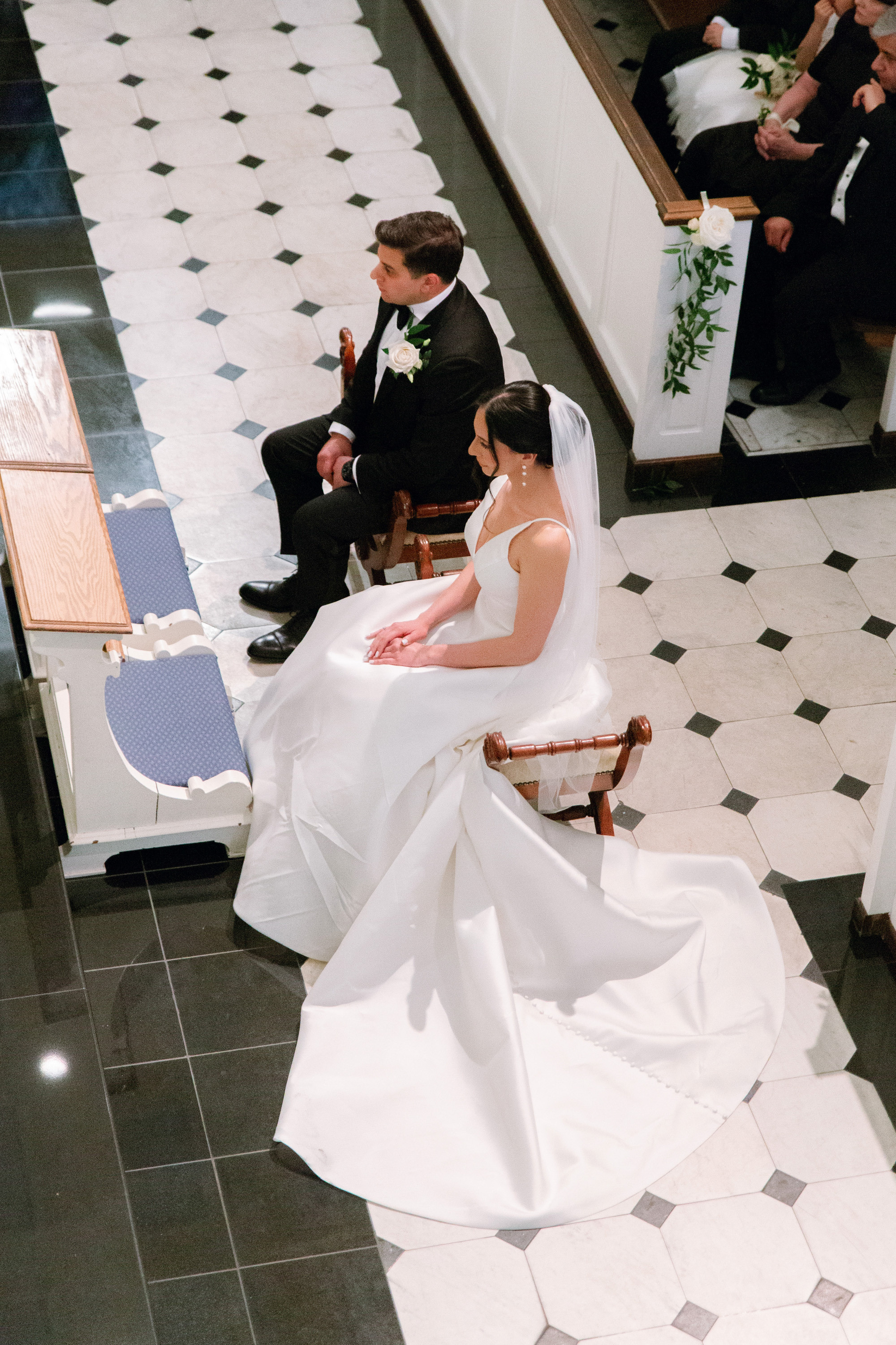 a bride and groom sitting on a bench