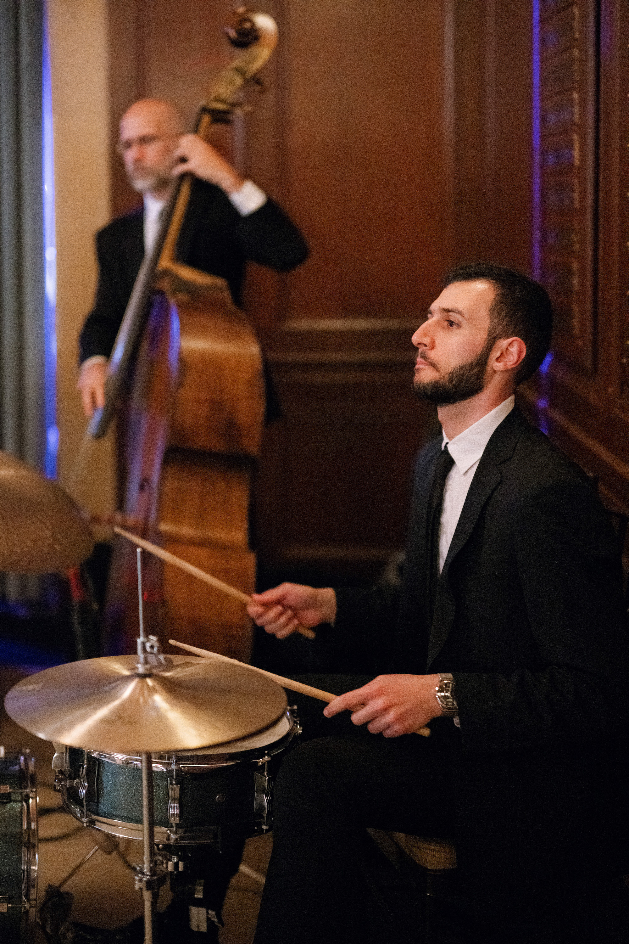 a man in a suit playing a drum