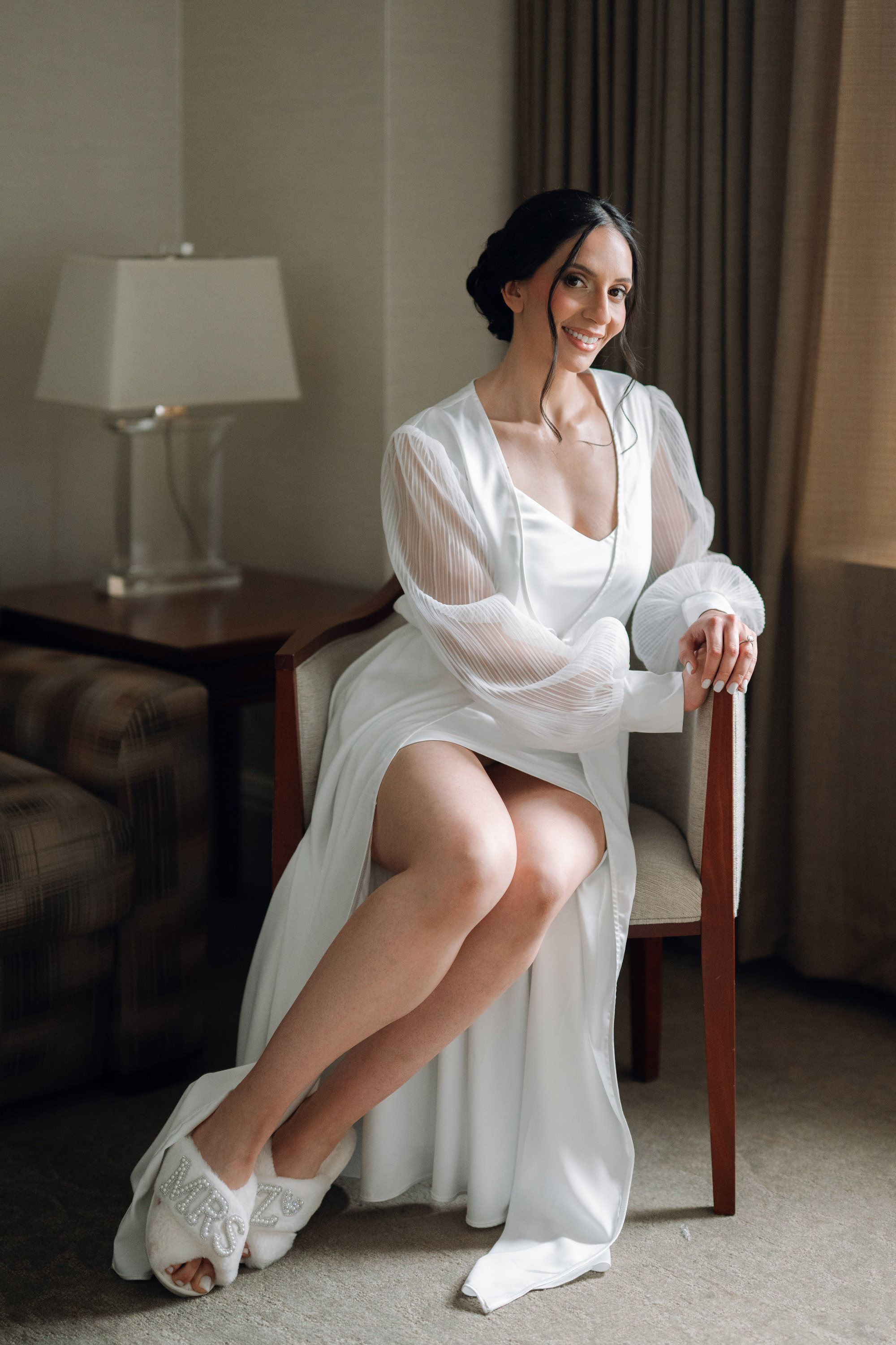 a woman in a white dress sitting on a chair