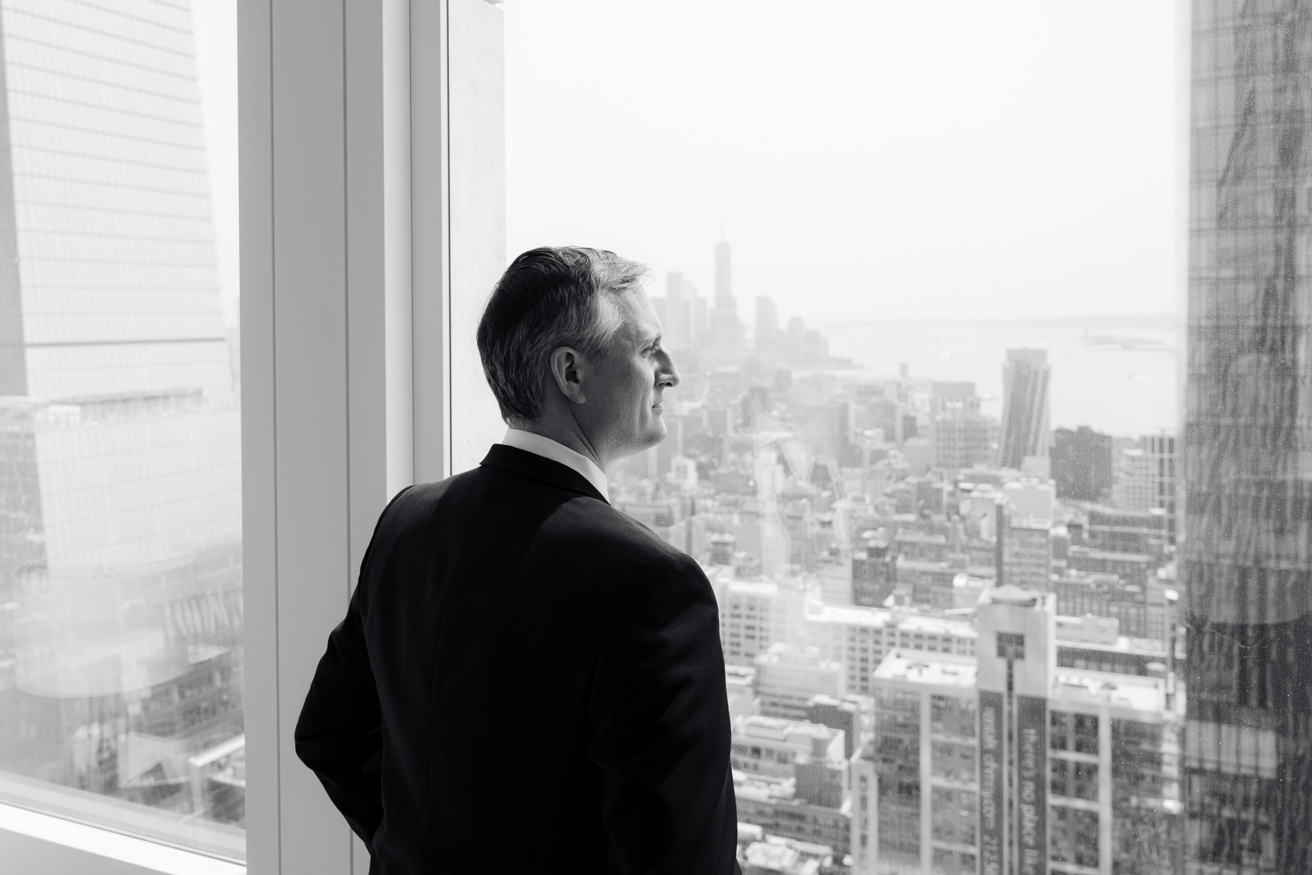 a man in a suit looking out a window