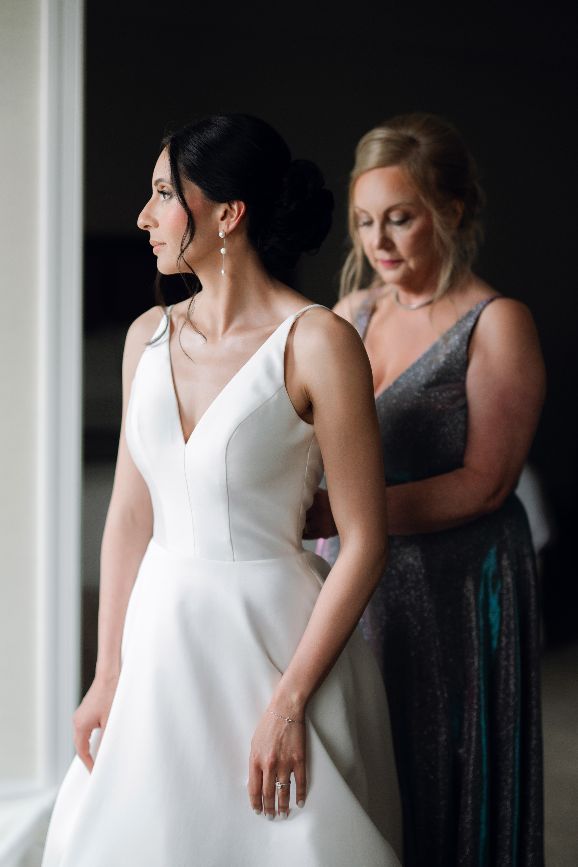 a woman in a white dress standing next to another woman