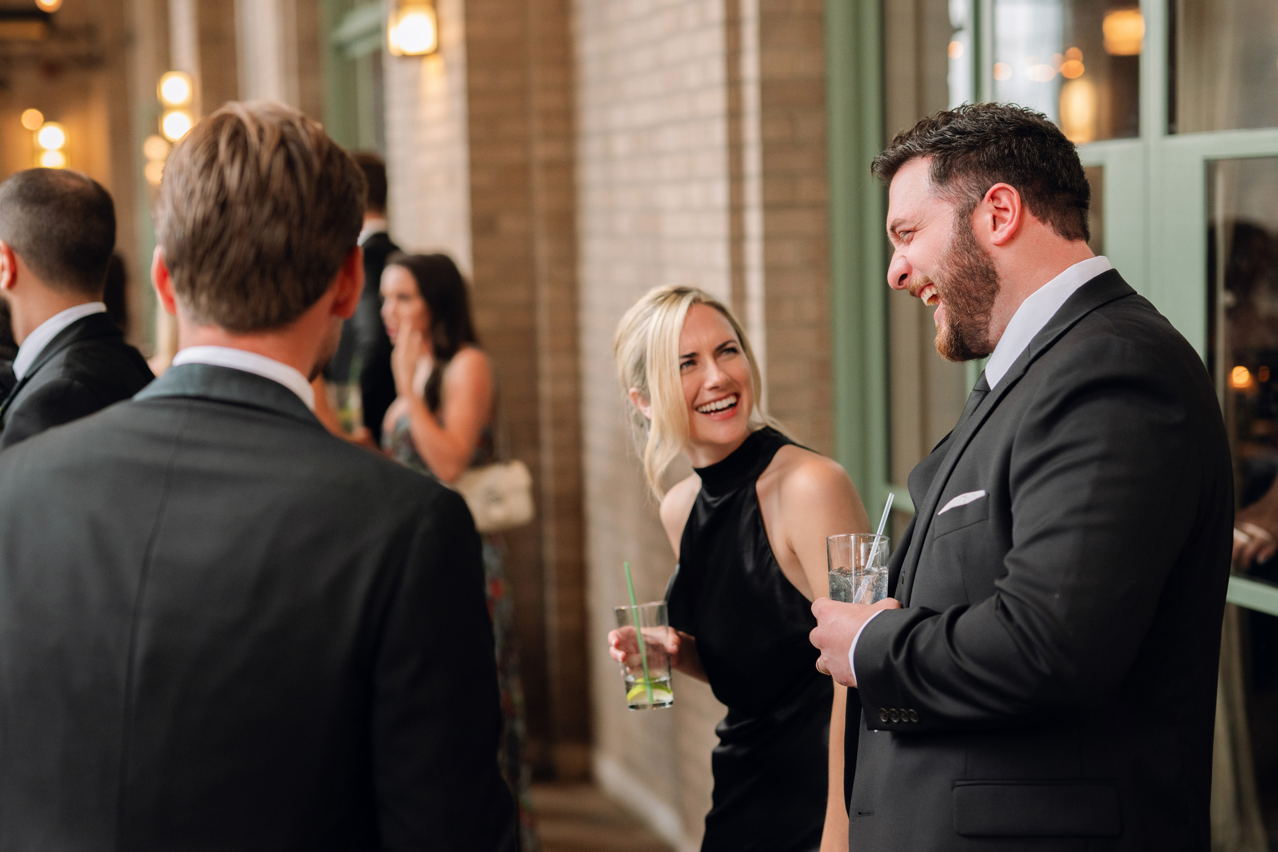 a man in a suit and tie talking to a woman in a black dress