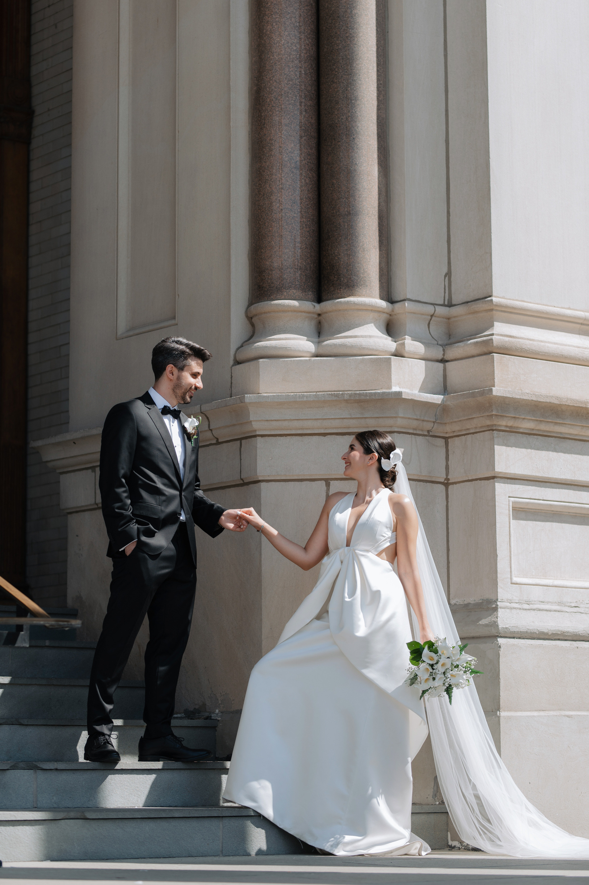 a bride and groom walking up the steps of a building