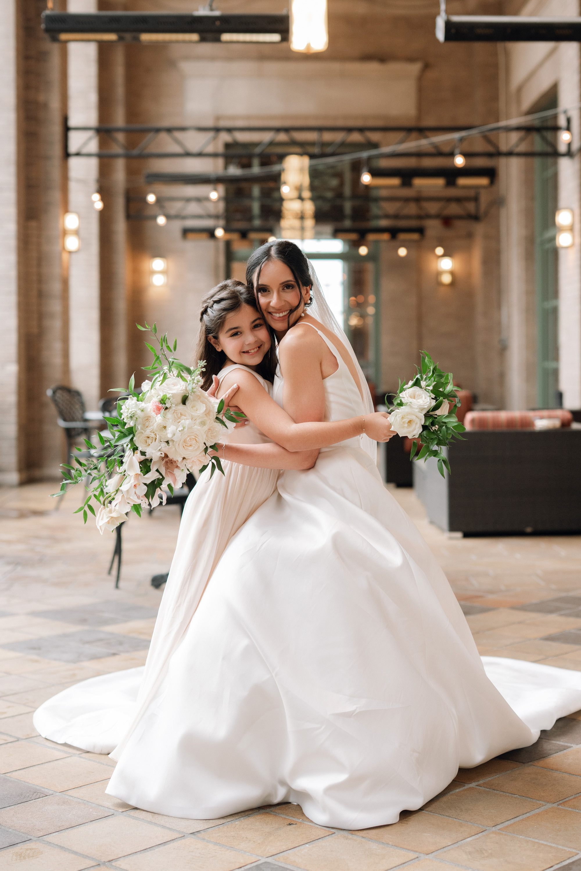 a bride and her maid pose for a photo