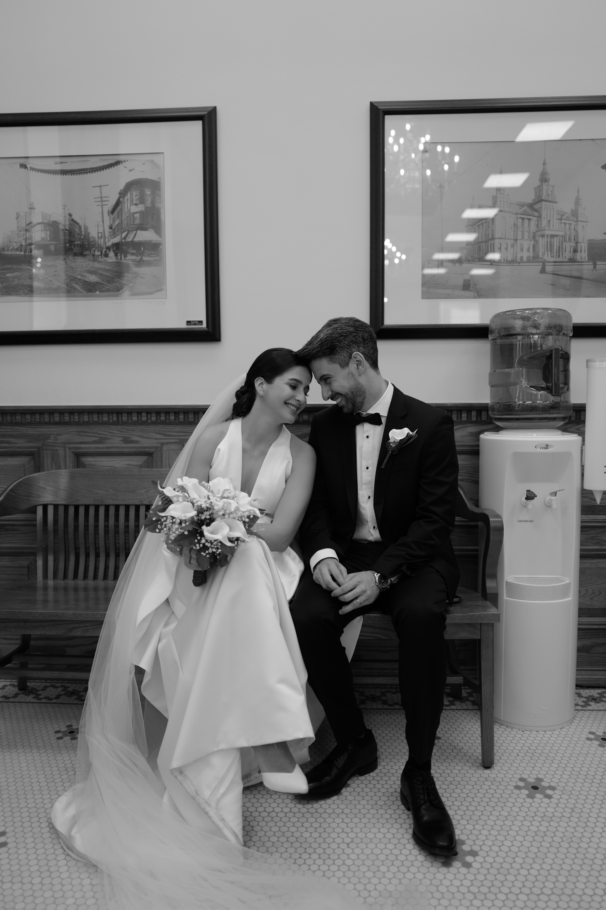 a bride and groom sitting on a bench