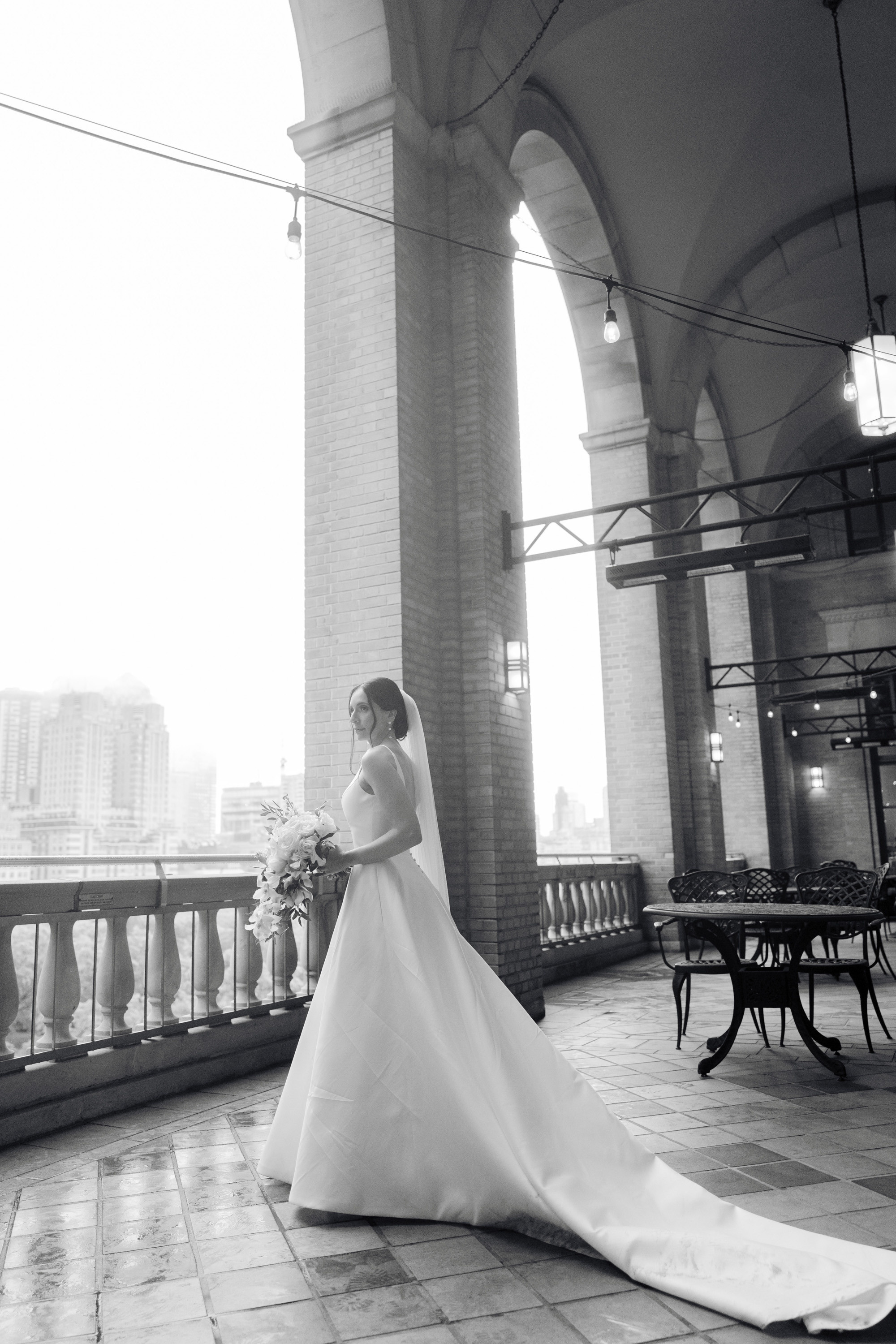 a bride standing on a balcony with a view of the city