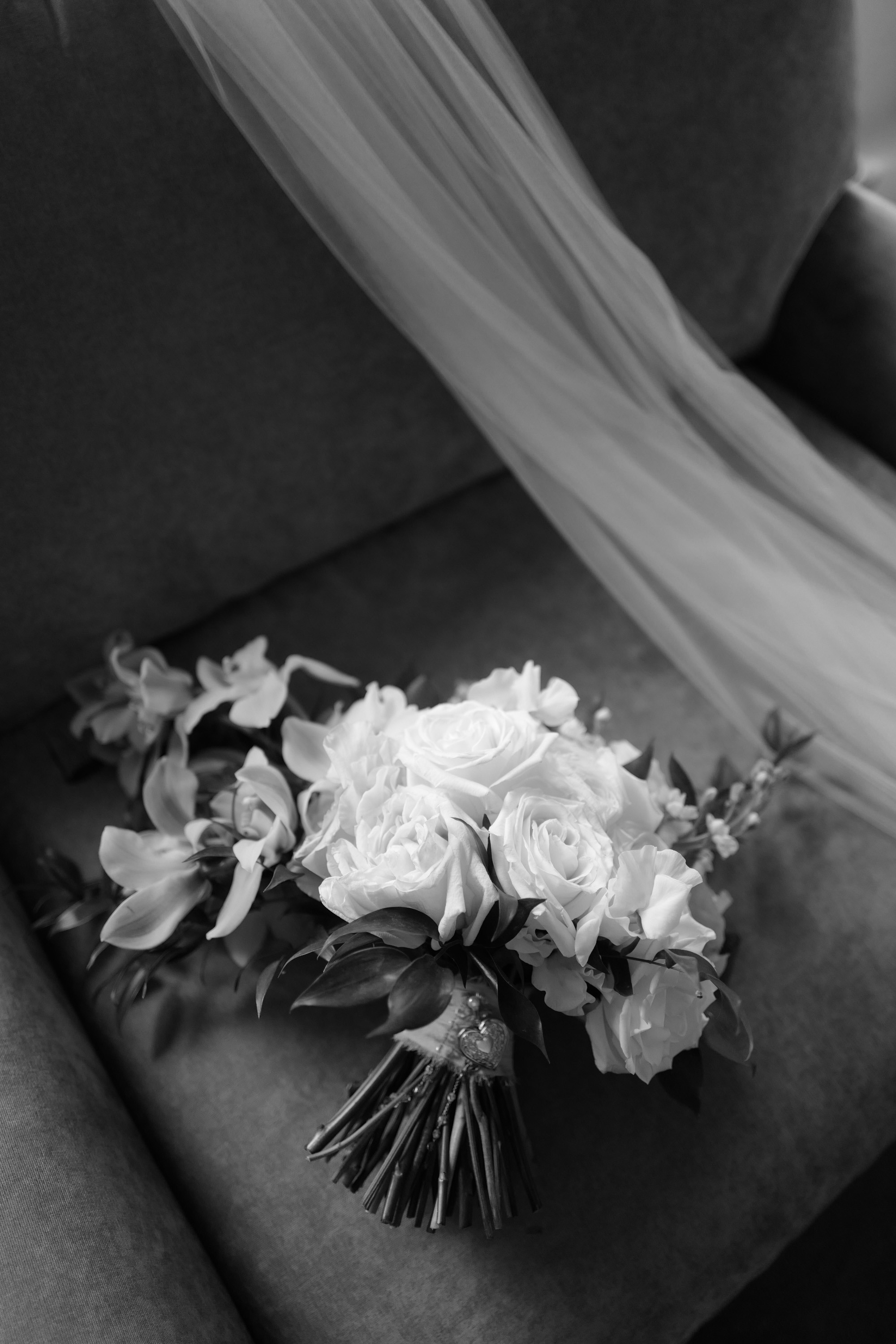 a bouquet of white roses and tulle on a couch