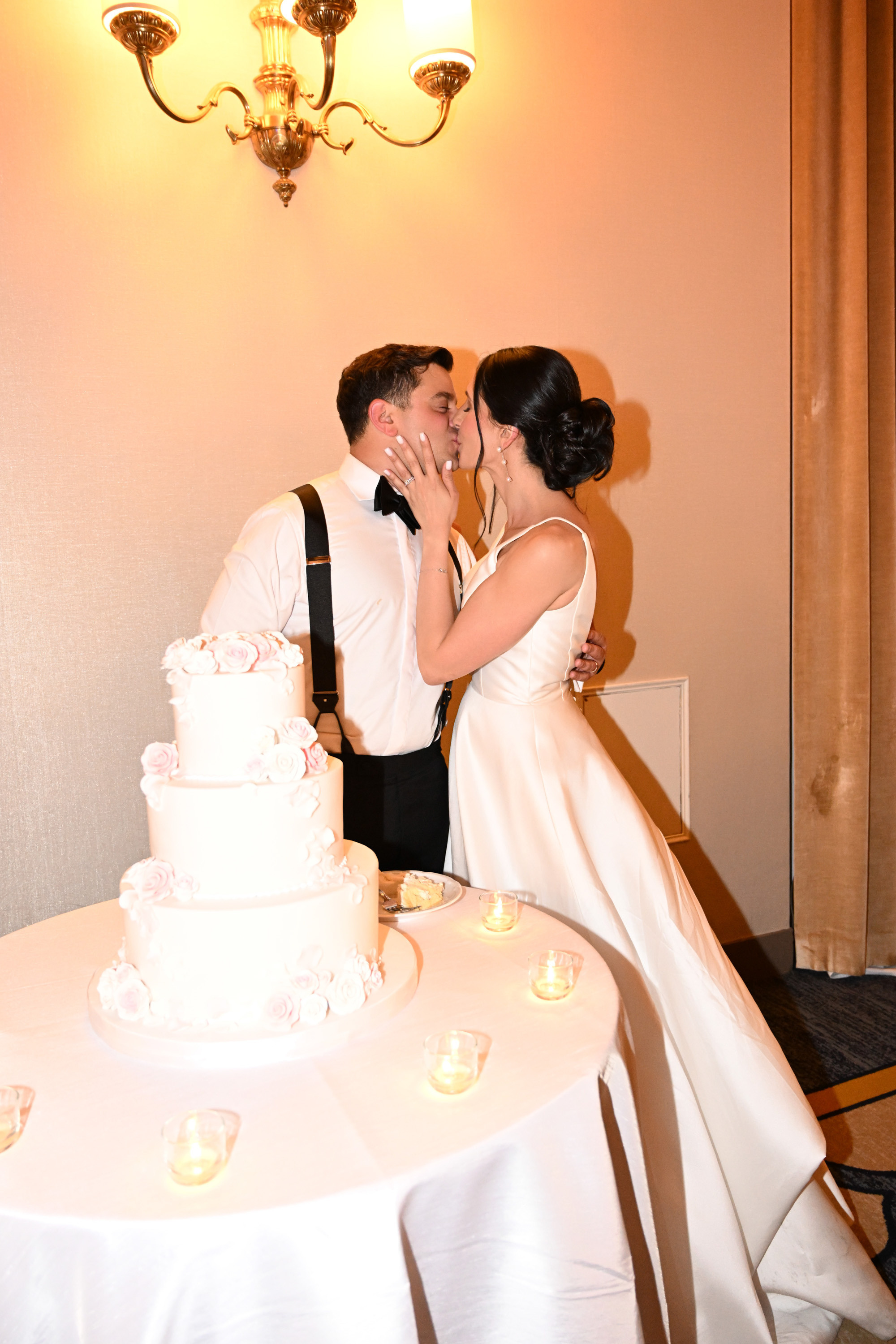 a bride and groom kissing in front of a wedding cake
