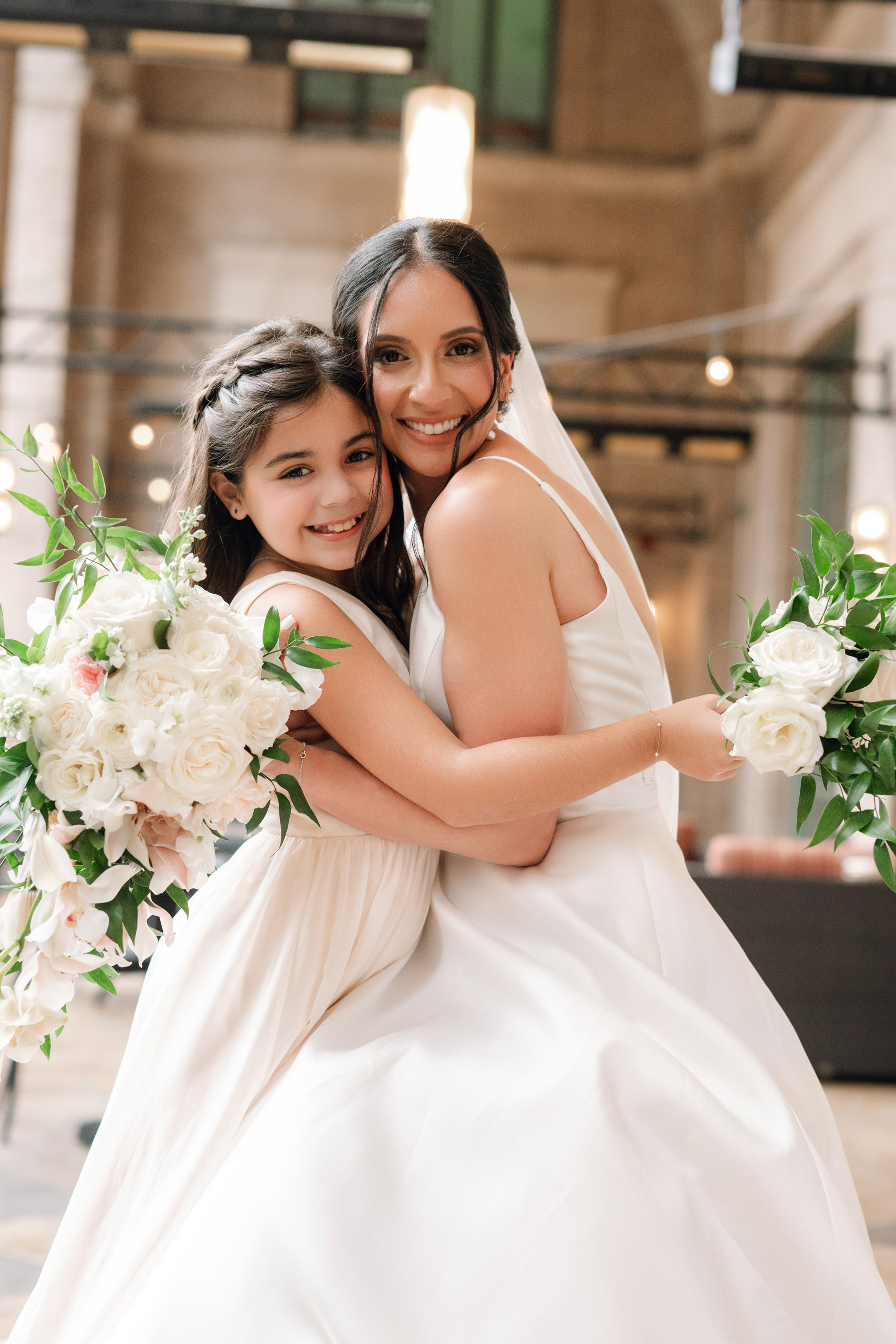 two women in white dresses hugging each other women