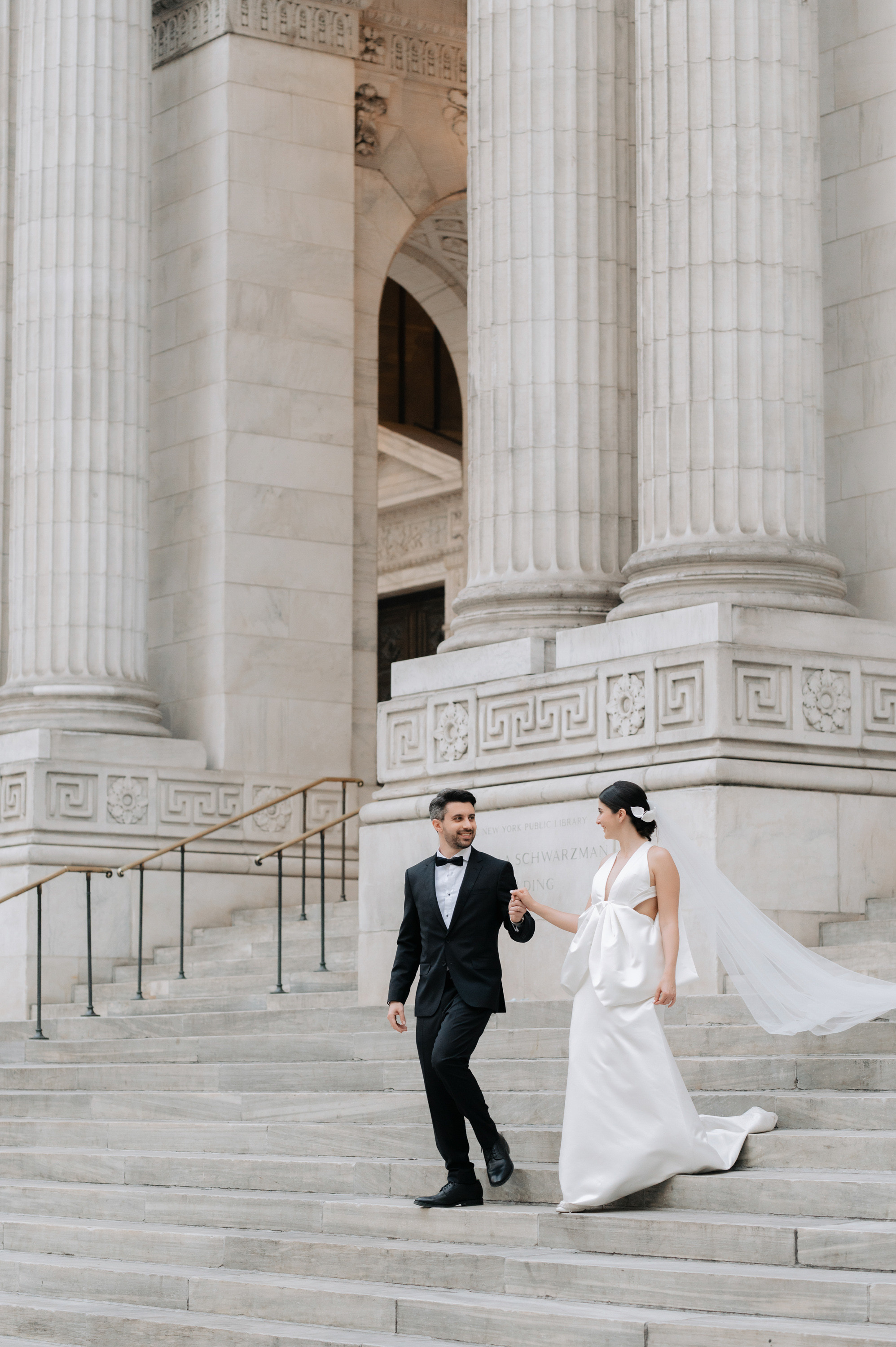 a bride and groom walking up the steps of the steps at the museum of fine arts