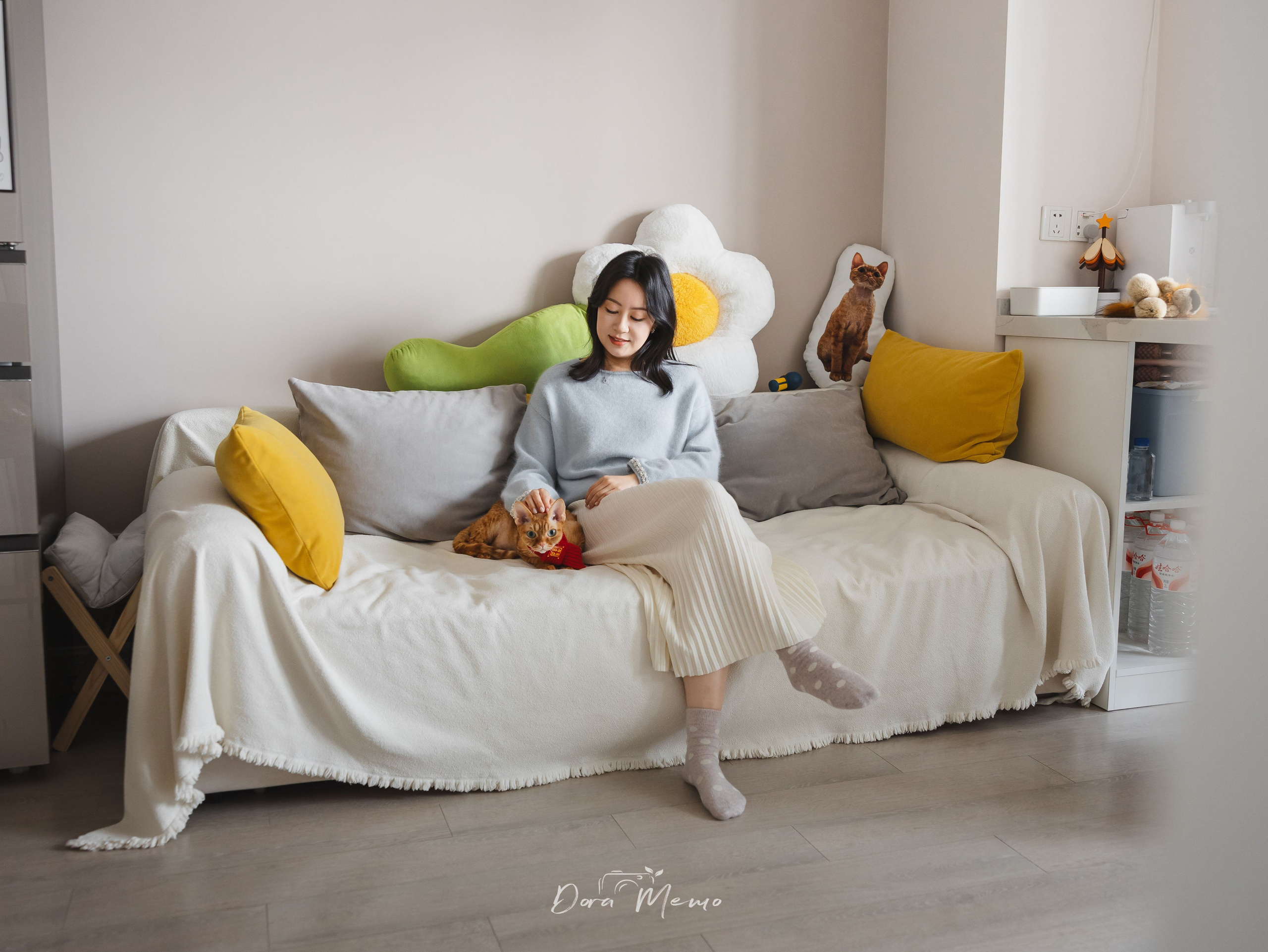 Devon Rex cat sitting with his owner on a couch during a cozy lifestyle pet photography session at home