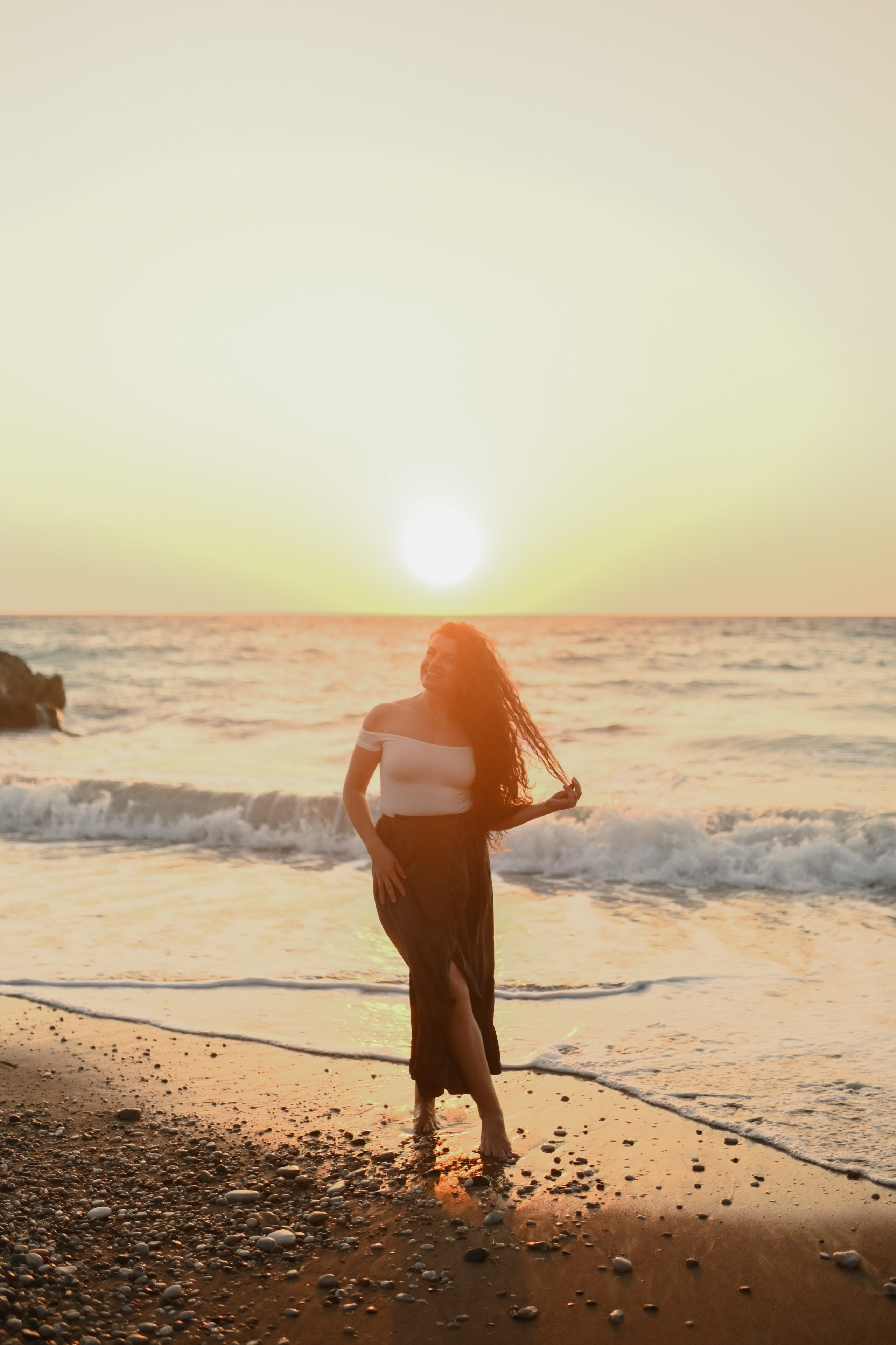 Happy family walking along a Rhodes beach at sunset. Photographer in Rhodes Island