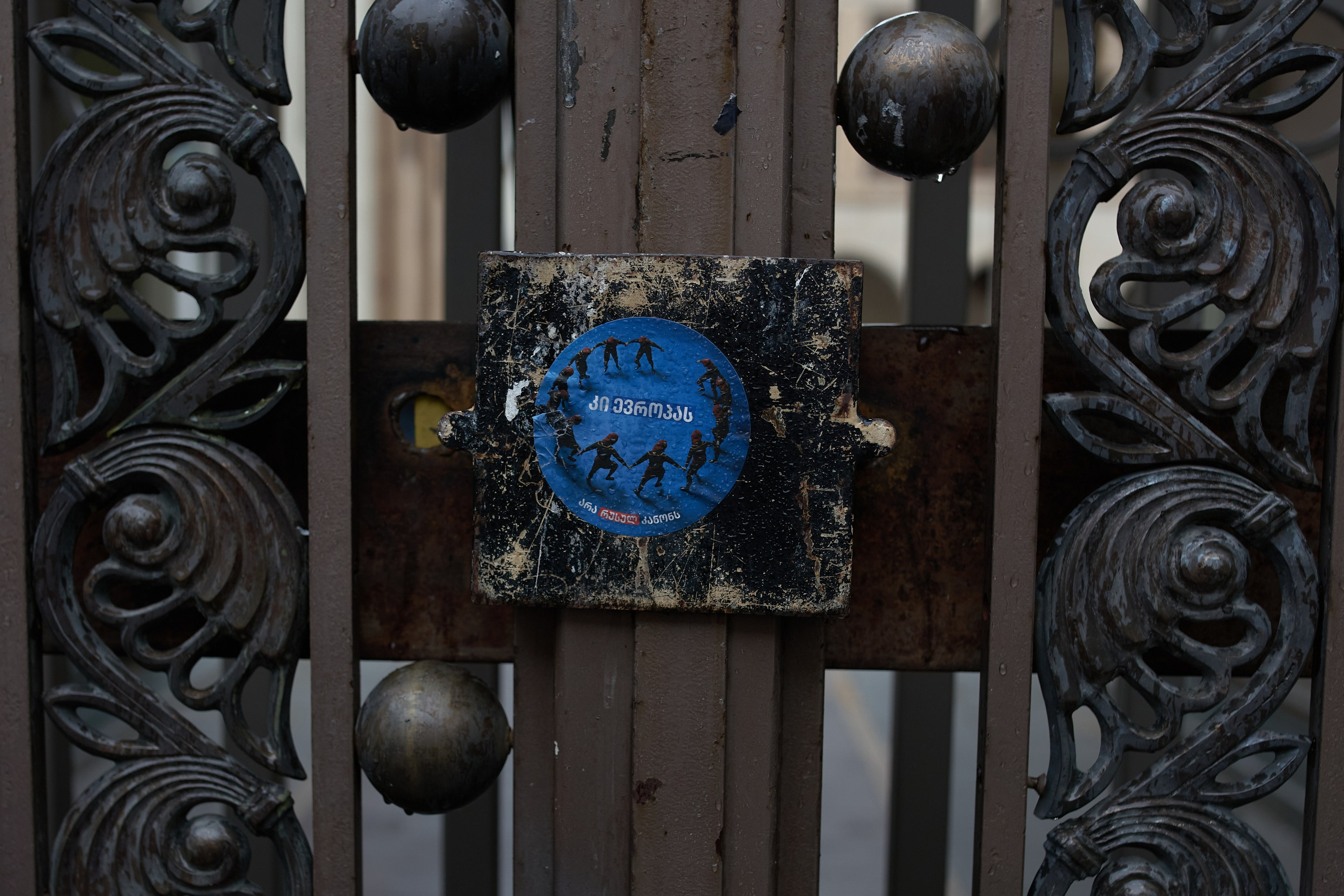 Sticker on the gates of Parliament. In large print in Georgian it is written “Yes to Europe”, in small print it is written “No to Russian law”.