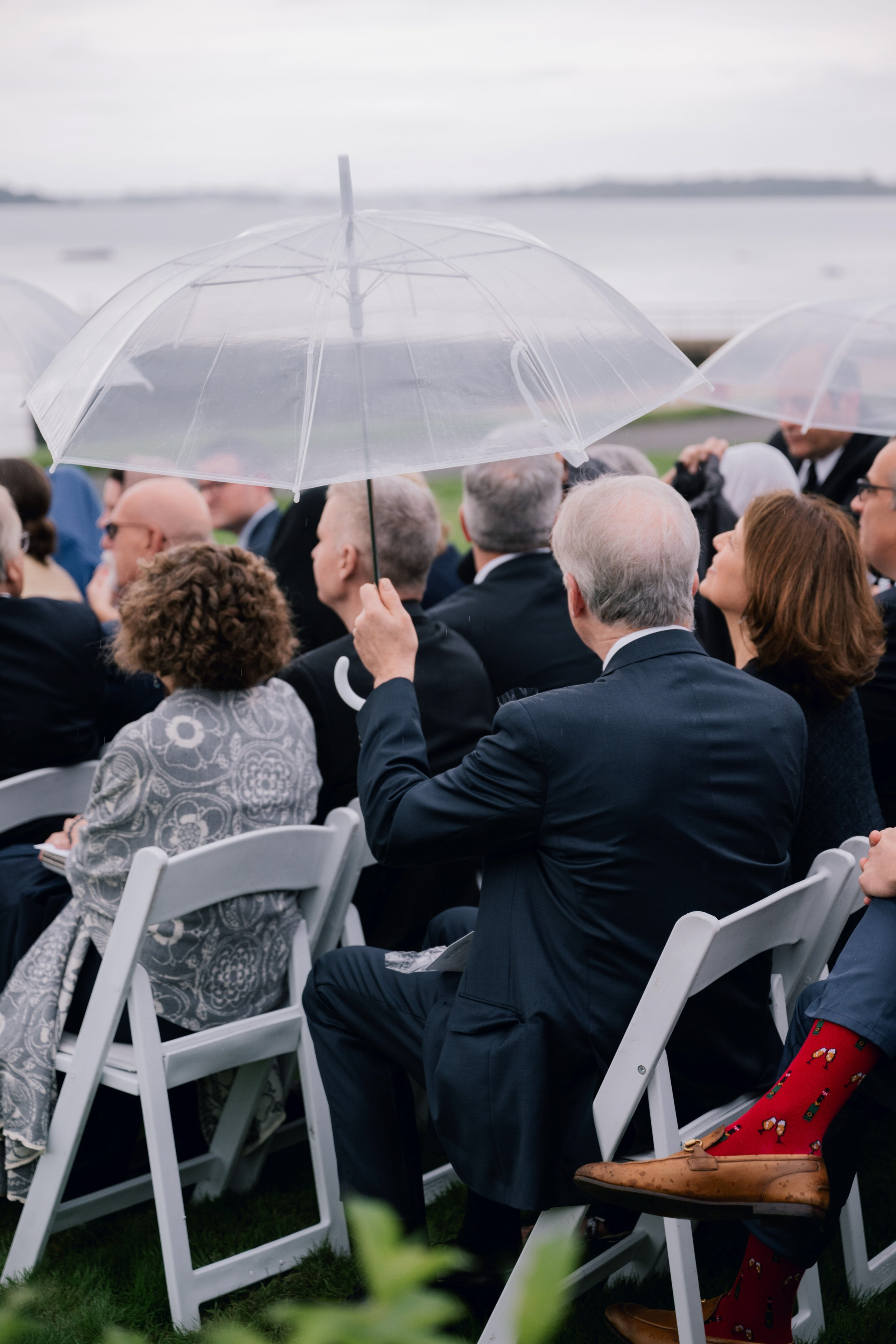 a group of people sitting in chairs under umbrellas