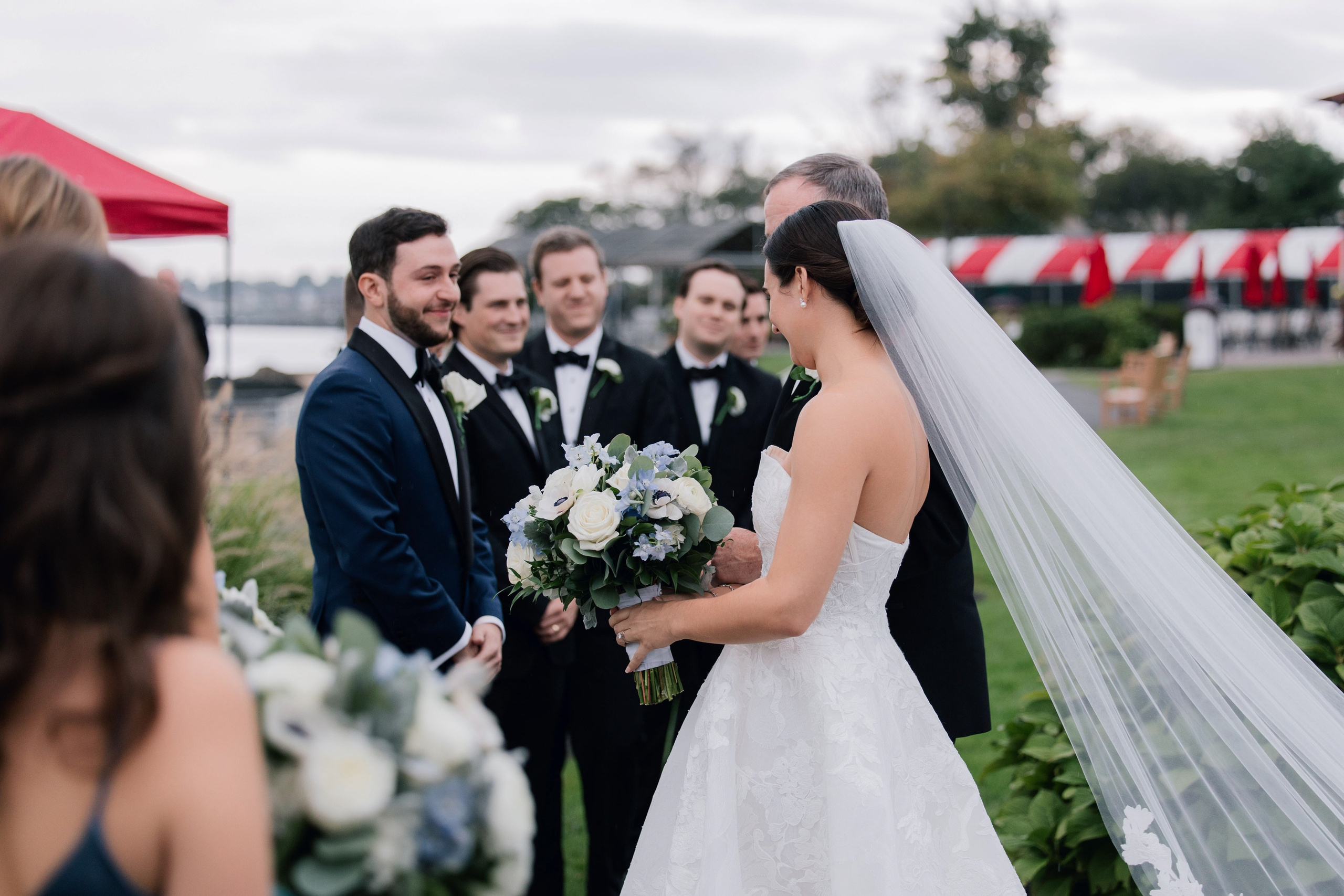 a bride and groom are standing in front of a red tent