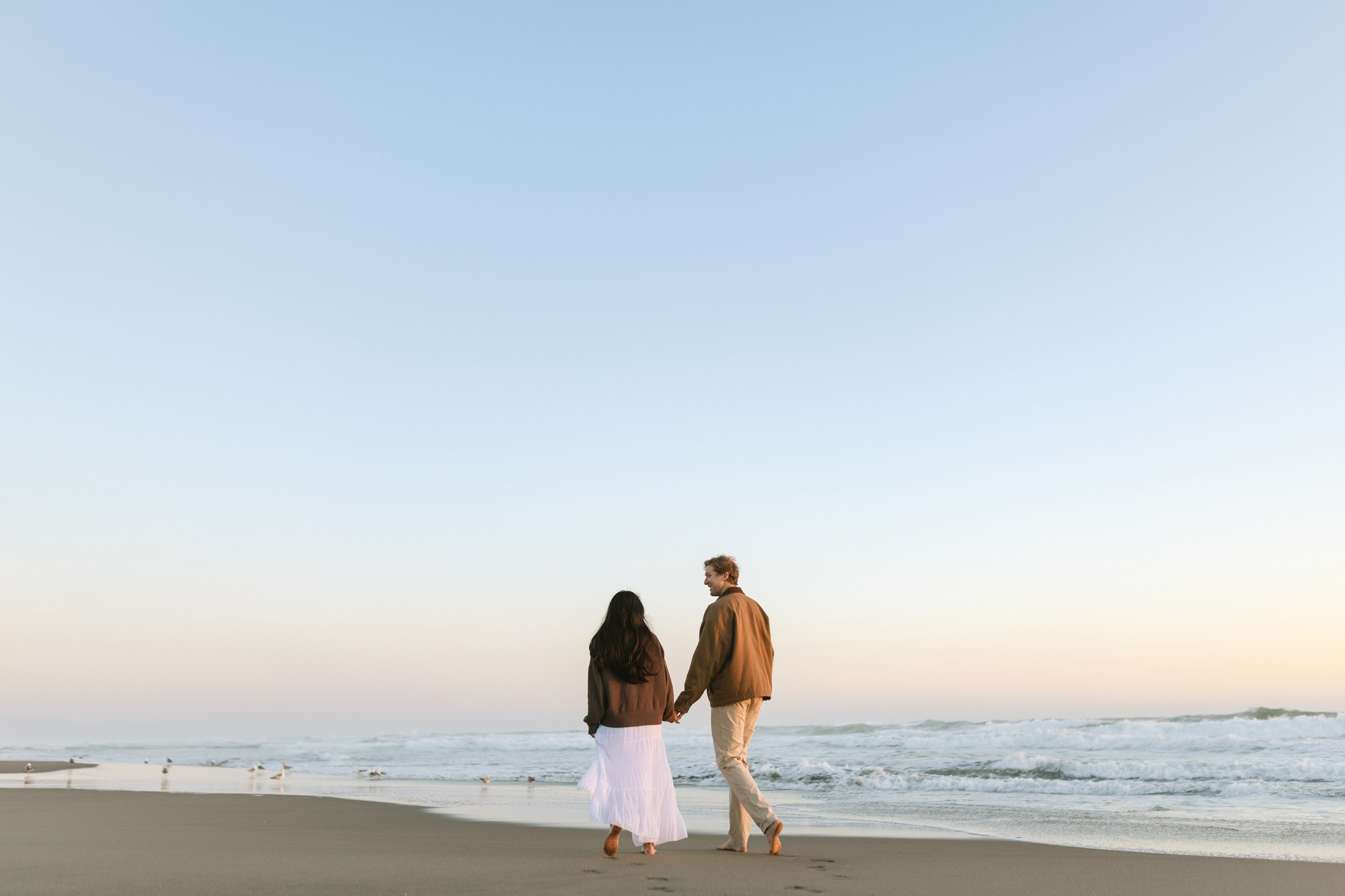 Maternity portraits with ocean waves and golden light in the Bay Area