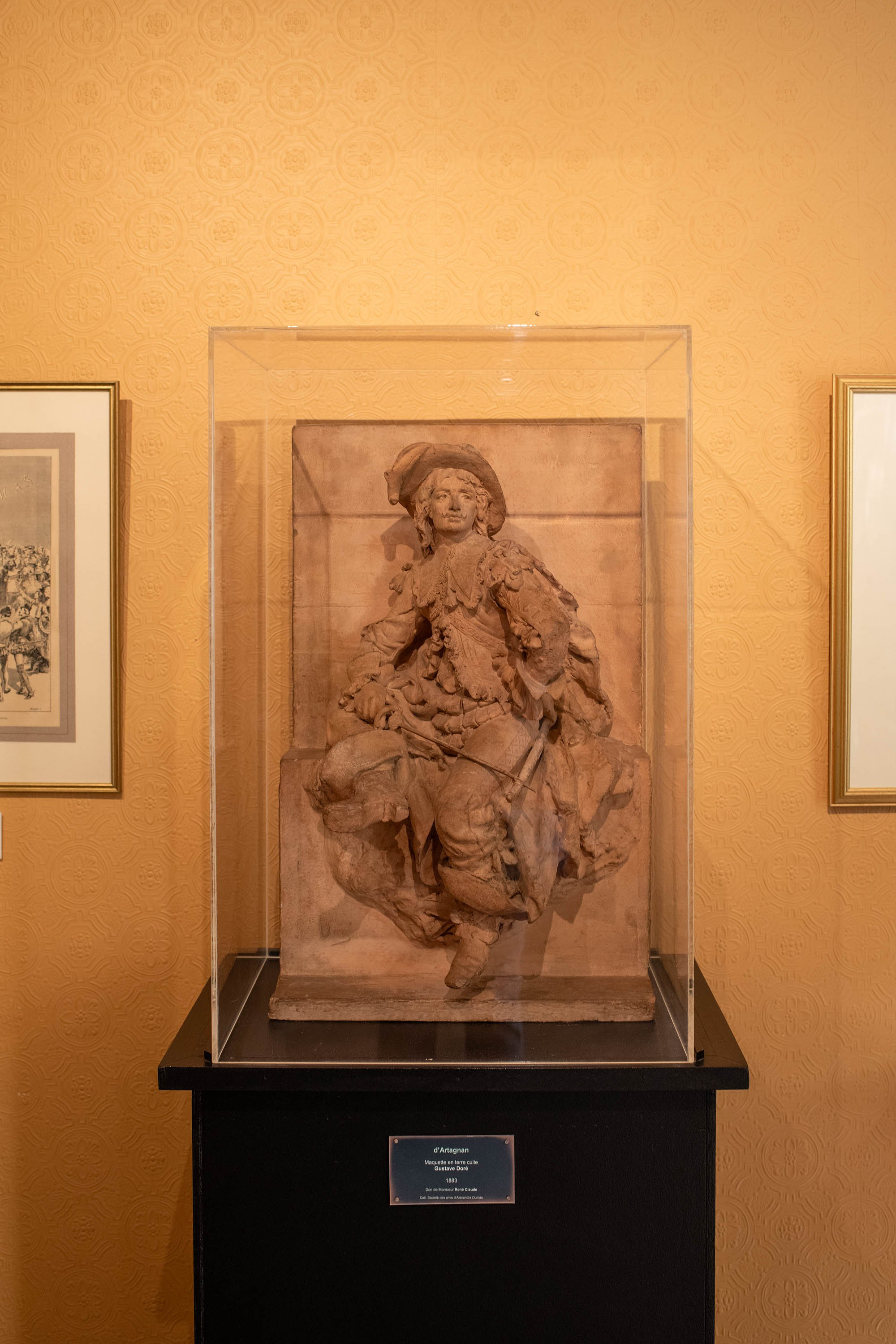 Sculptural model of d'Artagnan displayed in a glass case at the Château de Monte-Cristo museum in France.