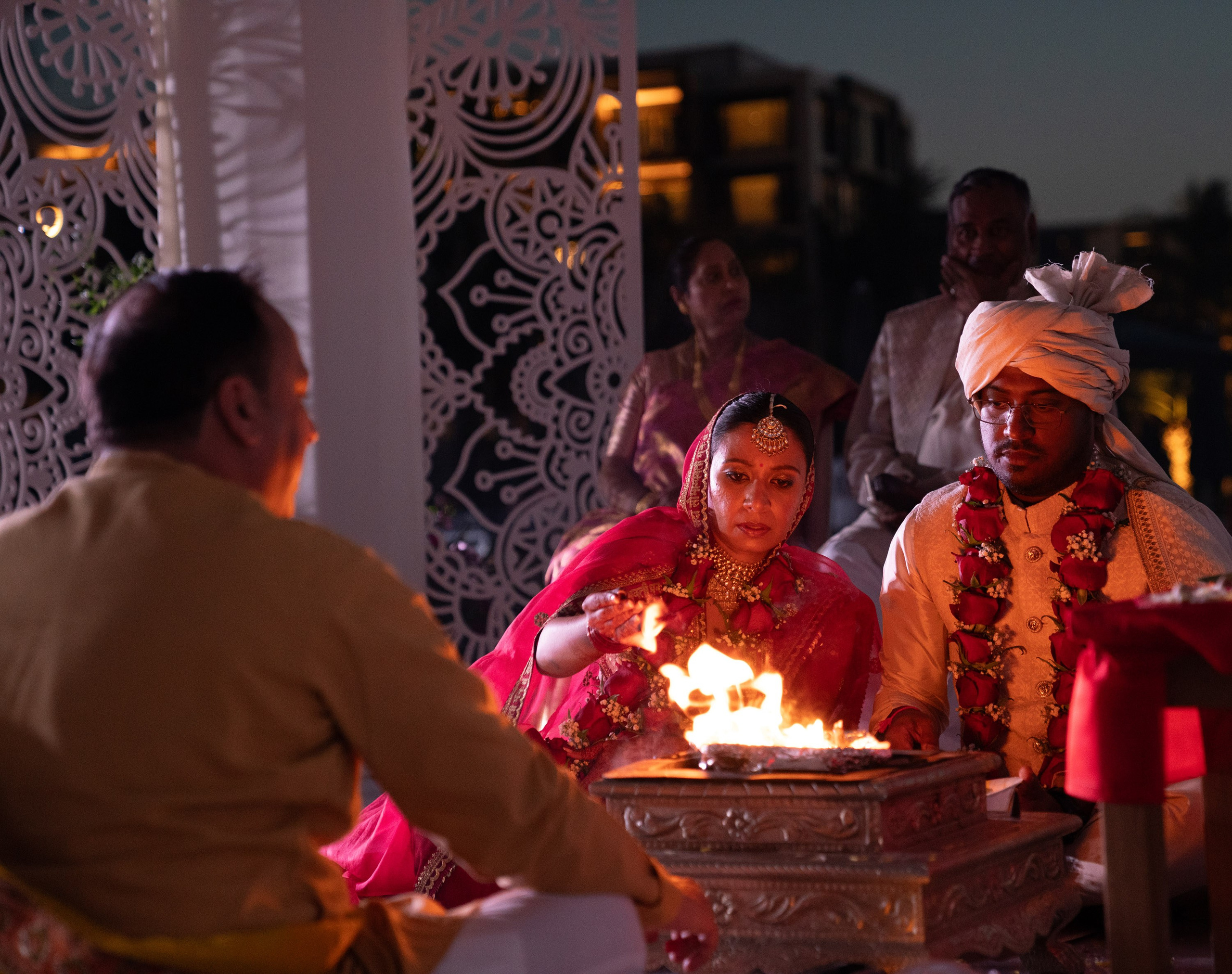 Bride and groom are seating near the fire during the indian wedding ceremony