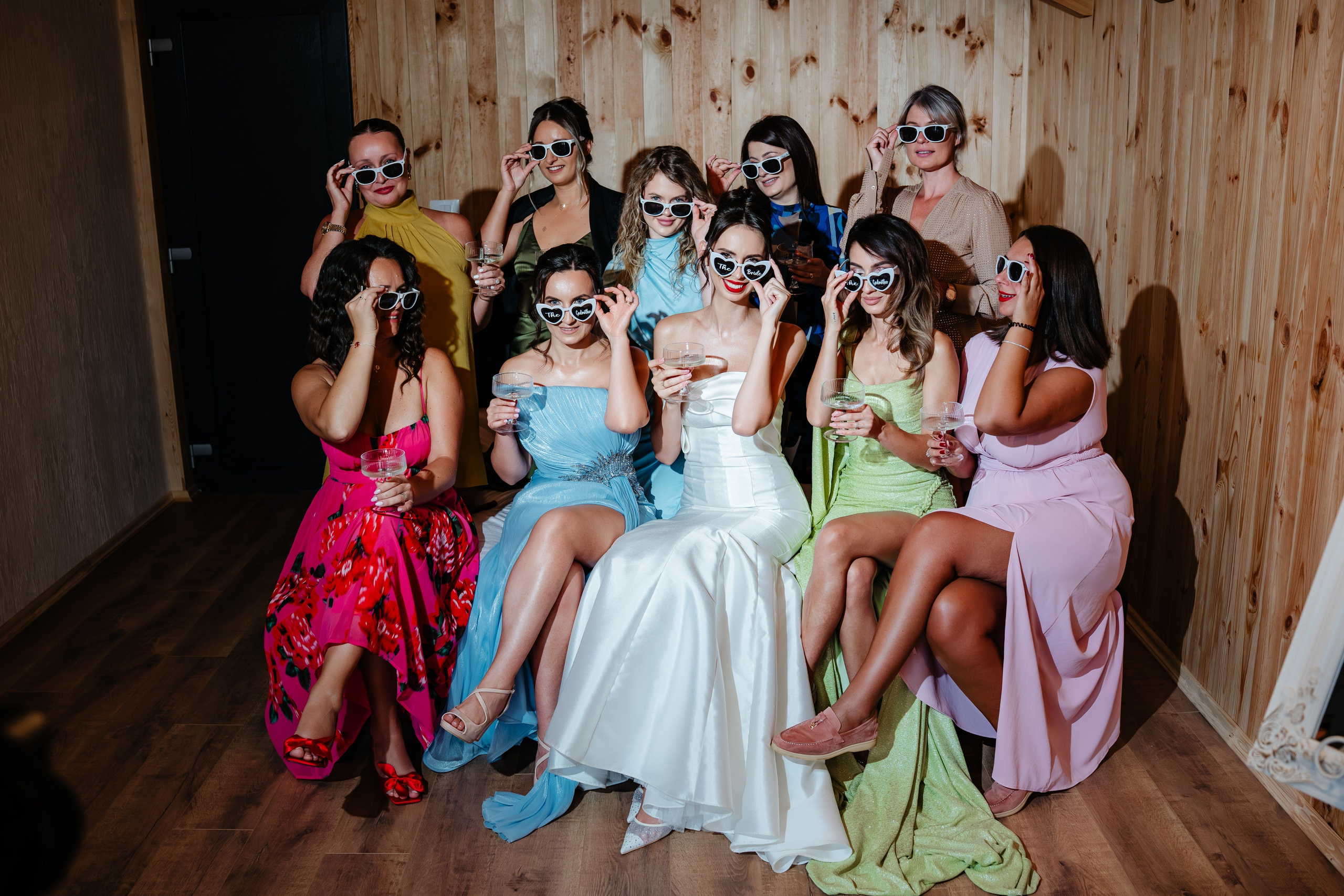 Mireasa și o domnișoară de onoare pozând în decorul de lemn al Cabanei Masiv.