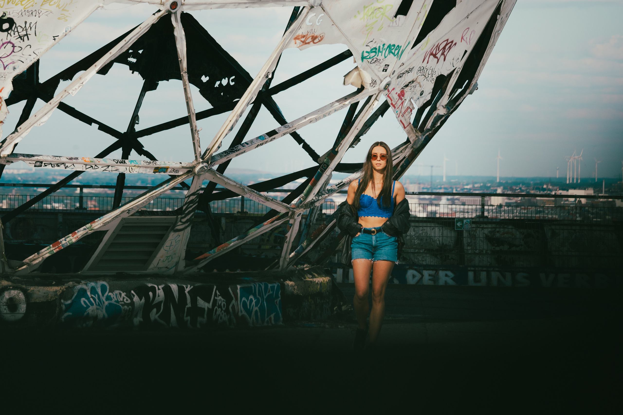 Female model posing in front of a colourful mural at Teufelsberg