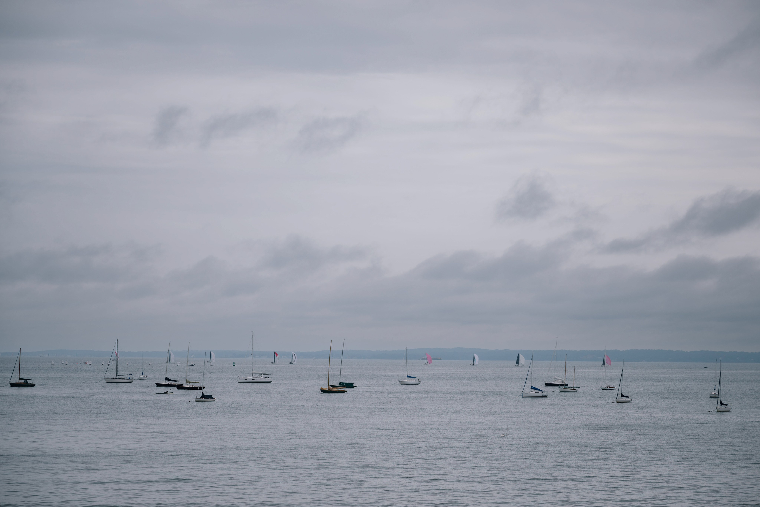 a group of sail boats floating in the ocean