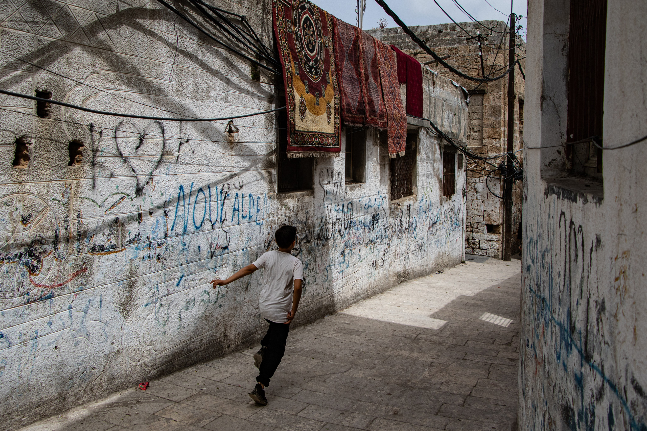Un jeune court dans les ruelles taguées de l’île d’Arwad.