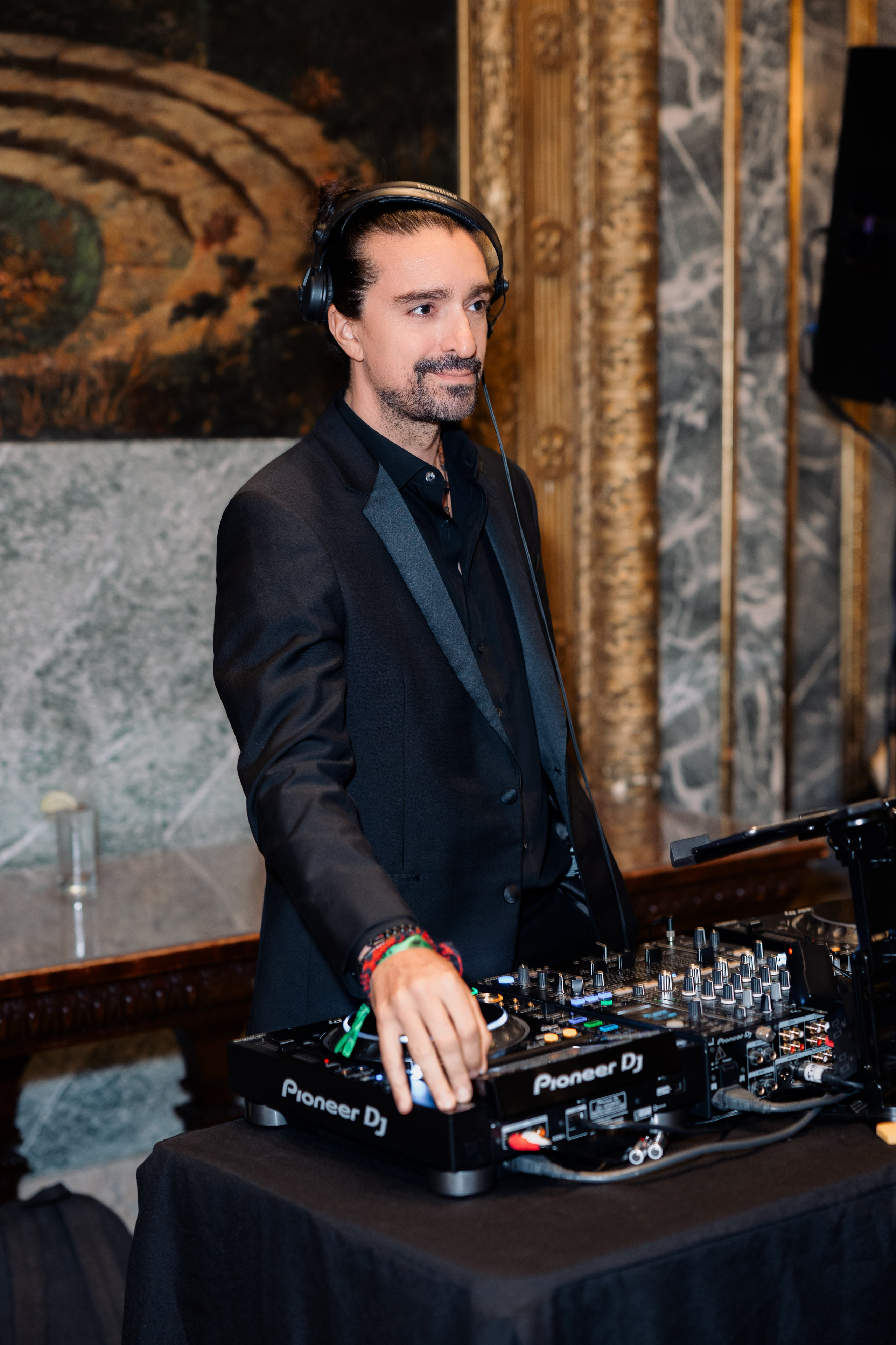 a man in a suit and headphones playing a dj
